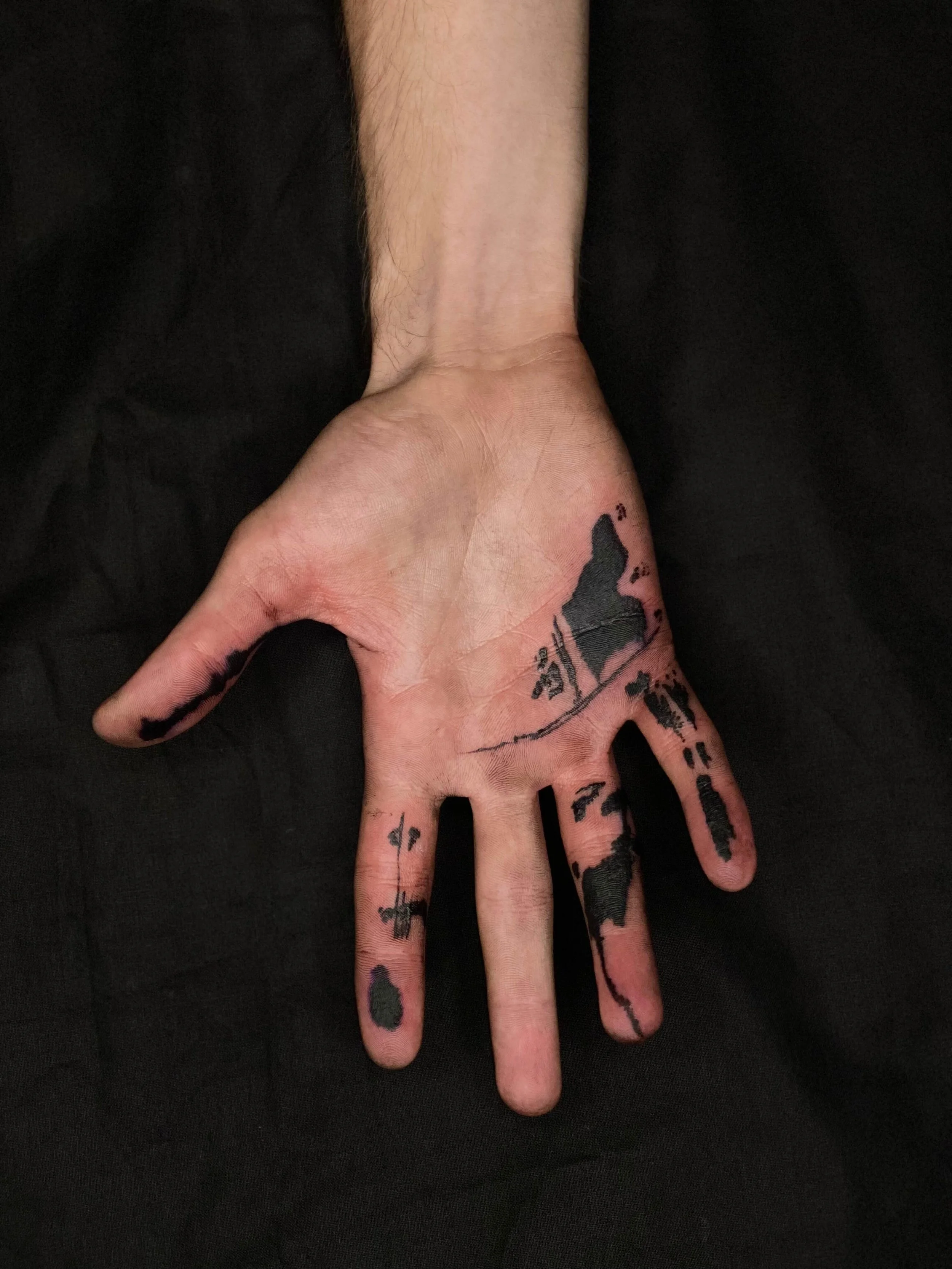 Abstract blackwork tattoo across the hand and fingers with mountain-inspired and graphic line elements.