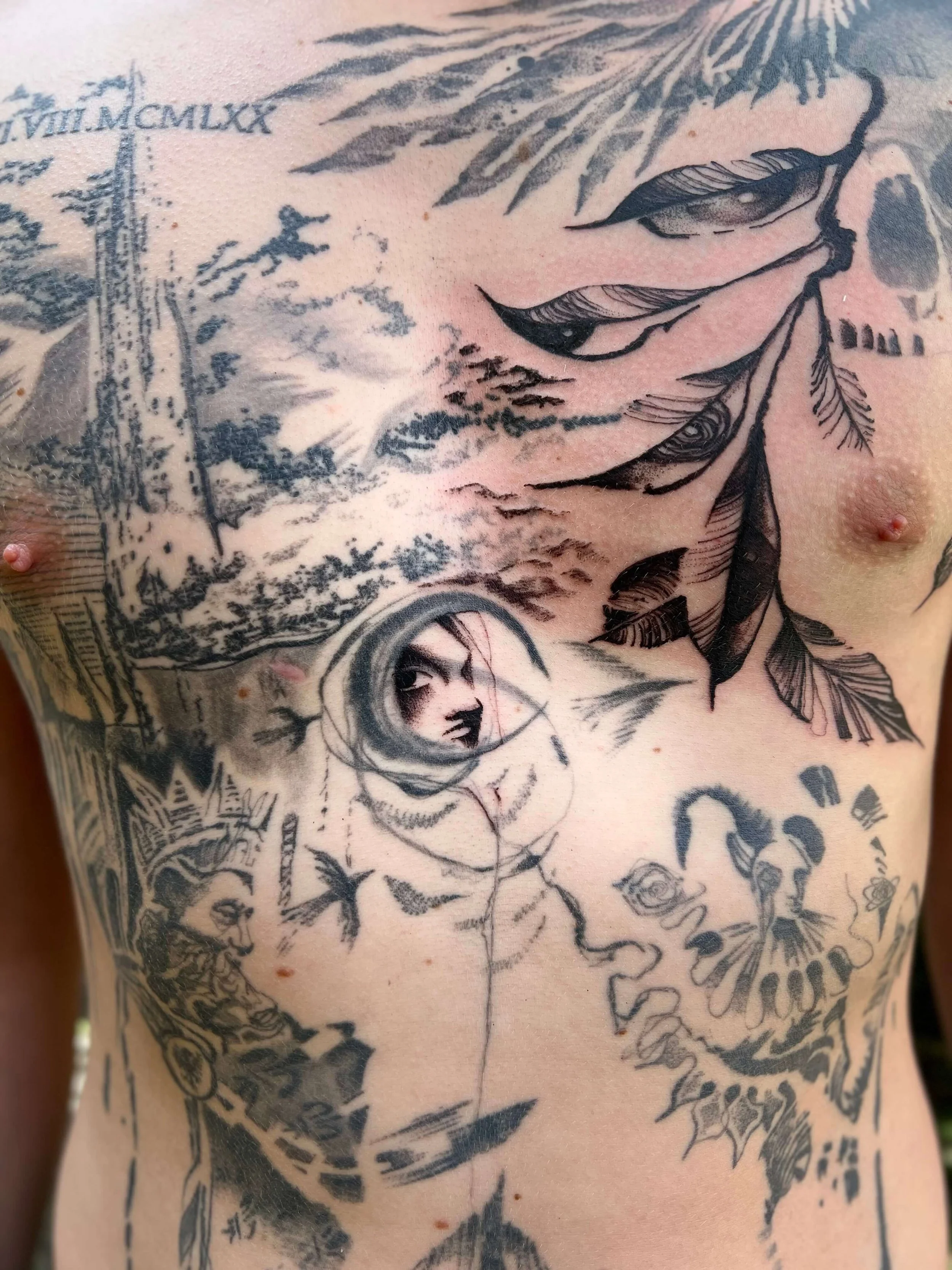 Large abstract blackwork chest tattoo combining figurative and organic elements in a dense graphic composition.