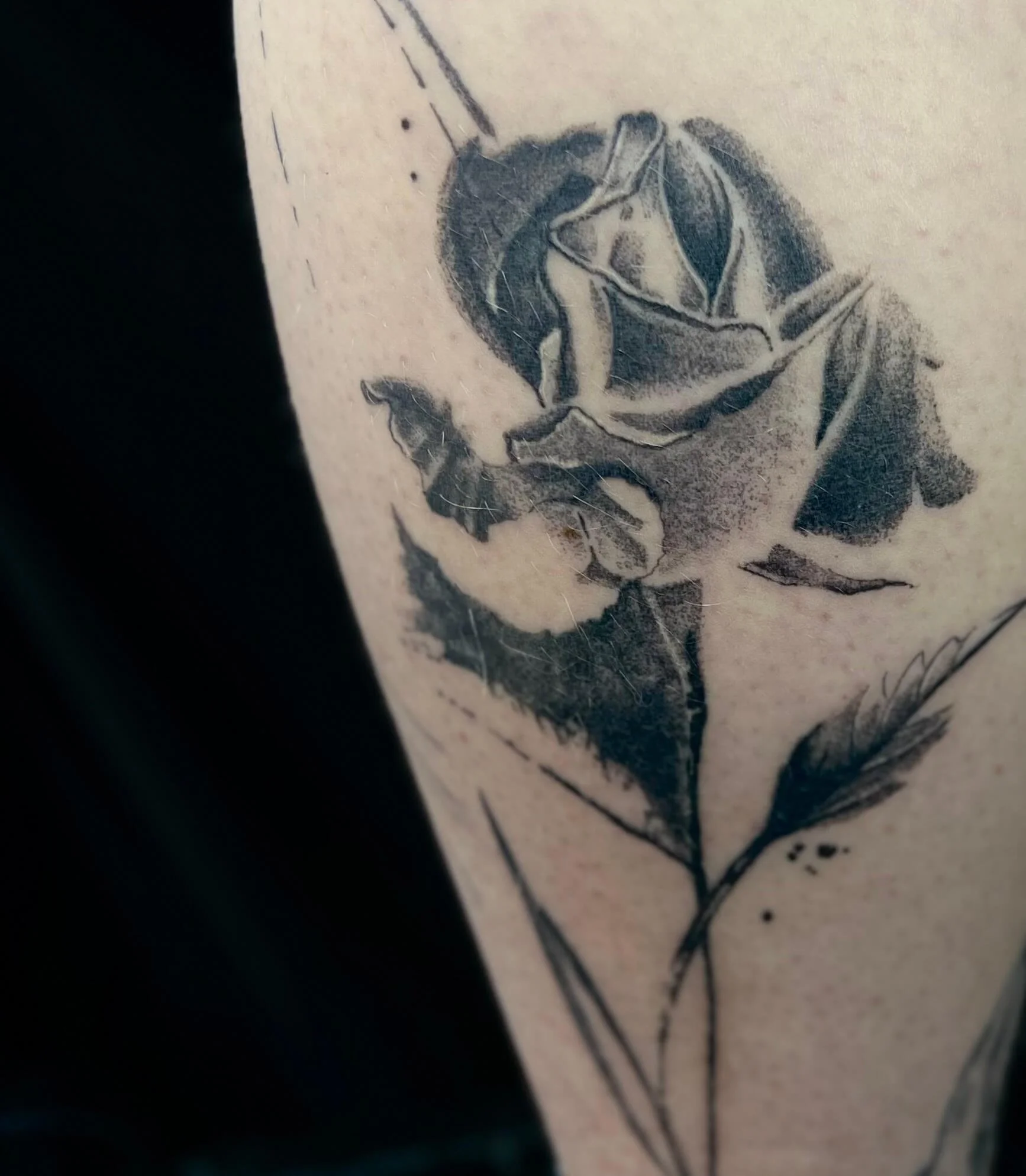 Abstract black and grey rose tattoo with refined shading and minimalist composition.