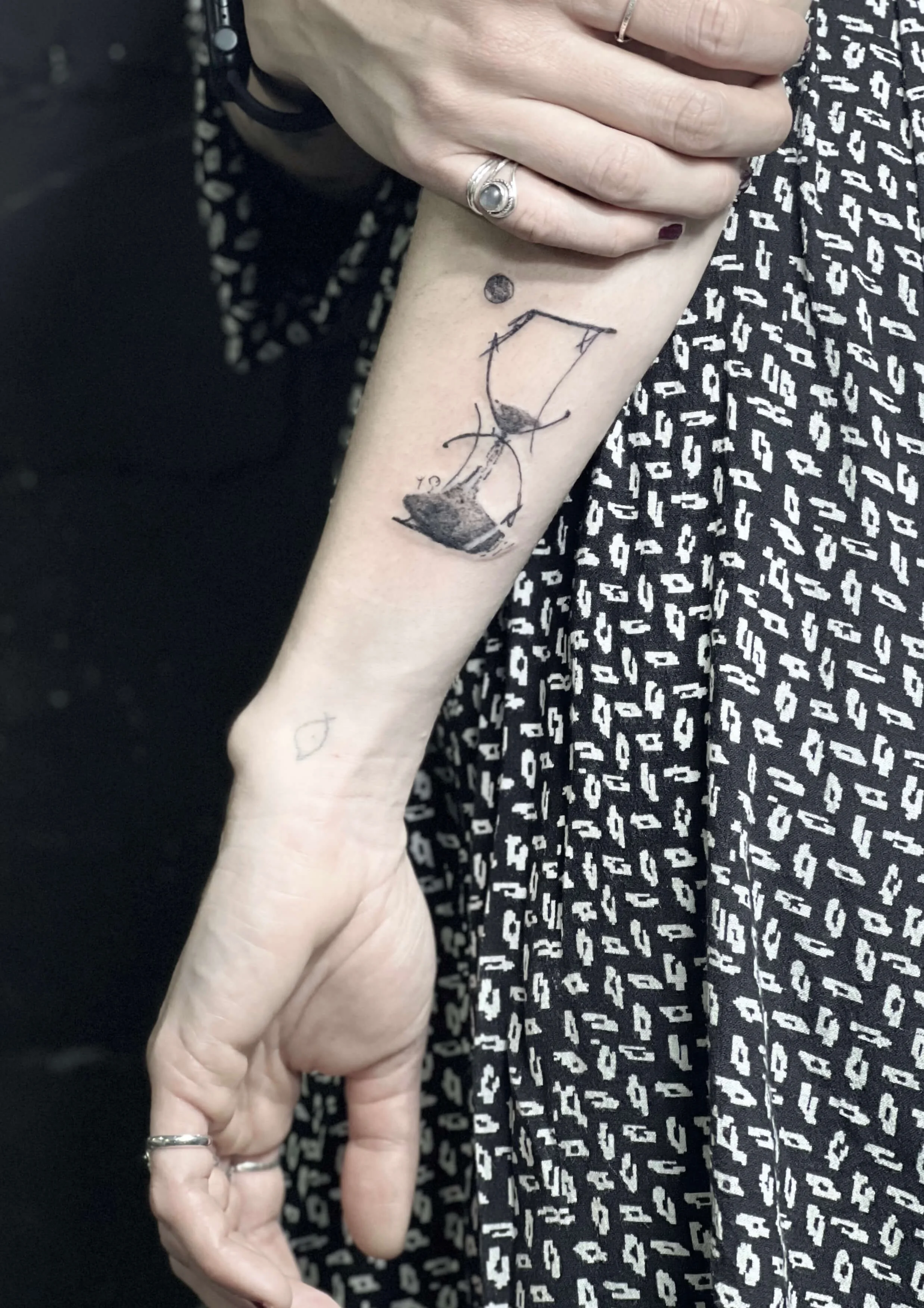 Sketch-style hourglass tattoo with minimalist dot detailing.