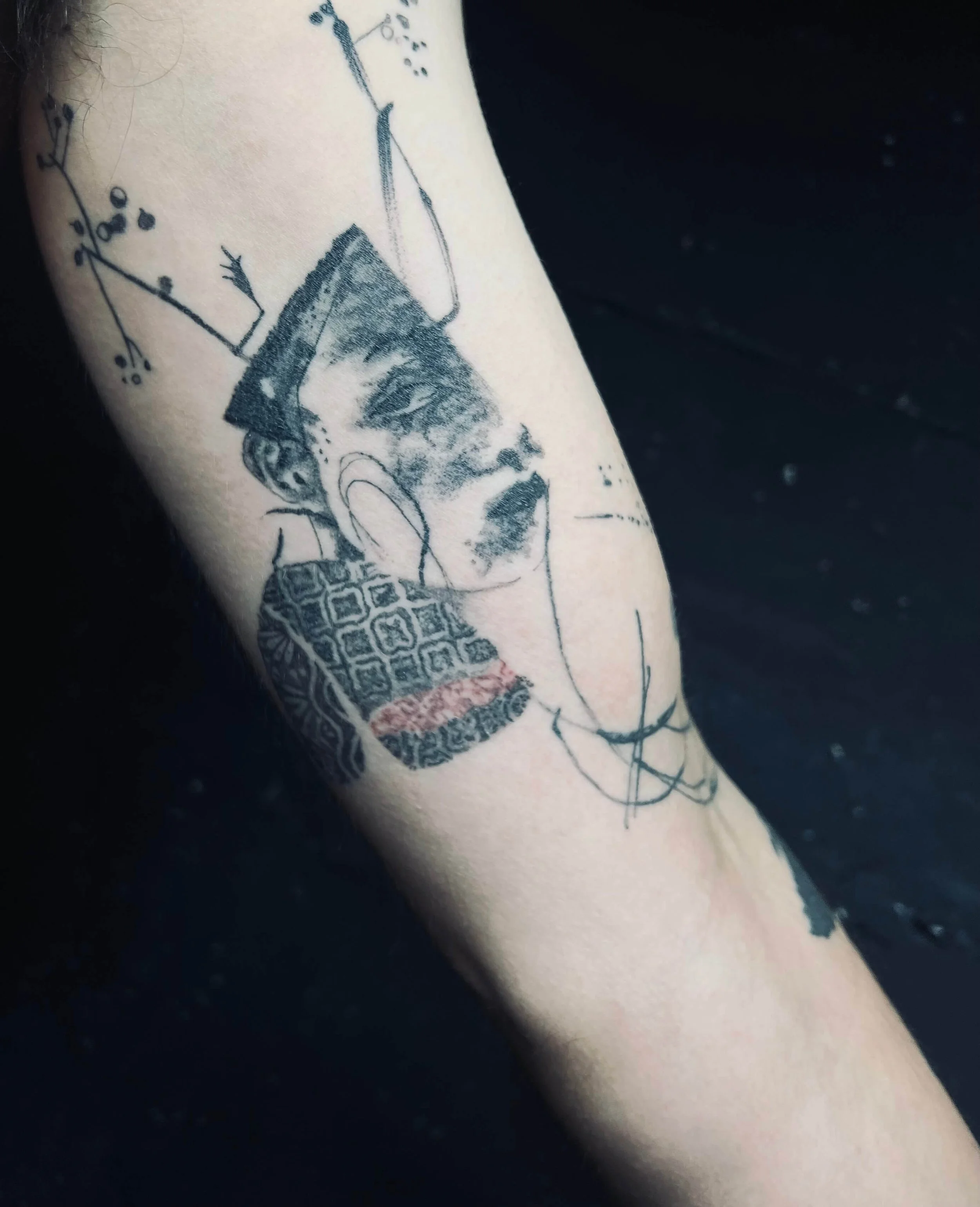 Contemporary blackwork portrait-inspired tattoo with expressive abstract elements.