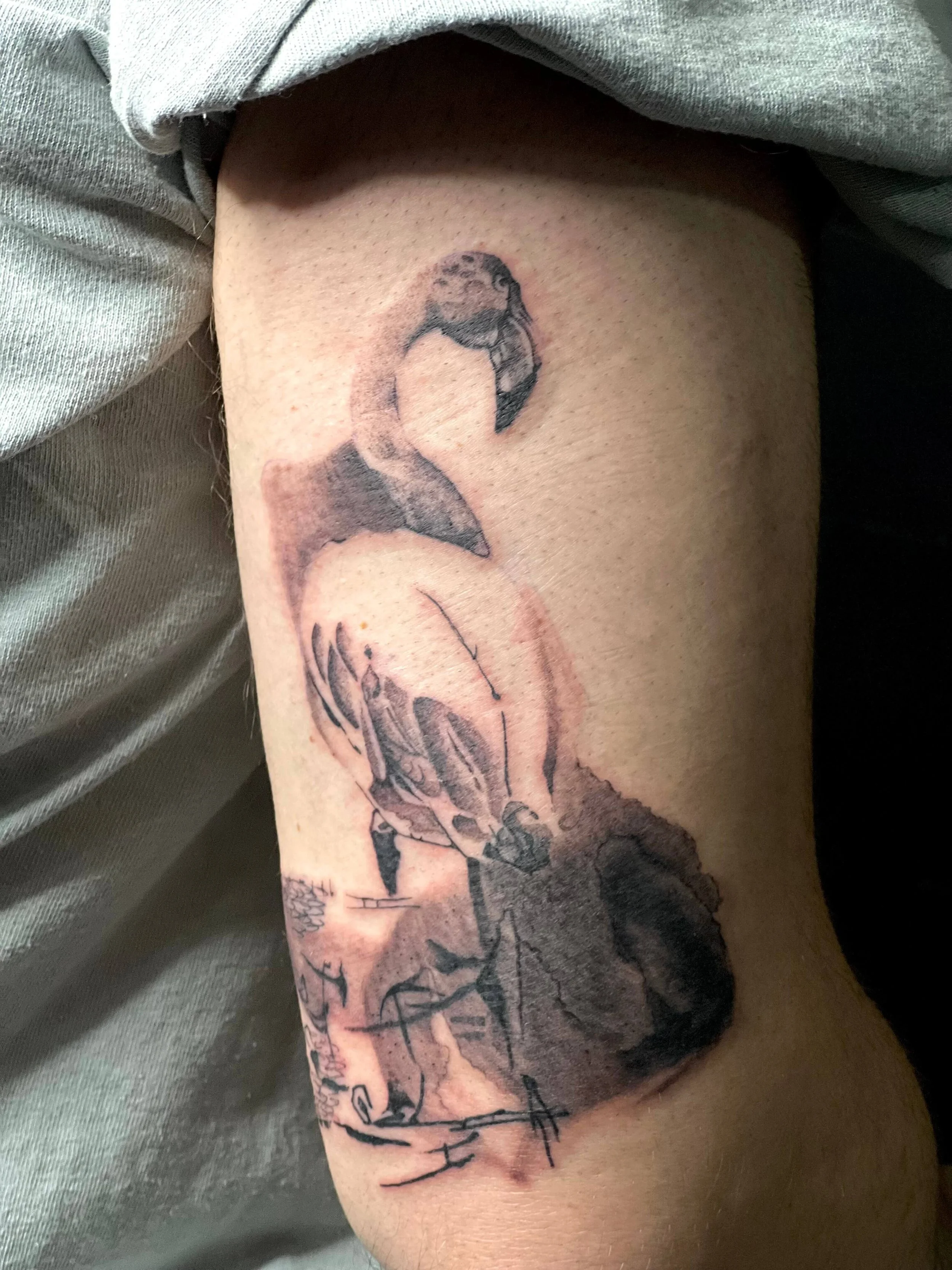 Tattoo of a woman’s face with a clock face and hands, inked in black and gray on a person's arm.