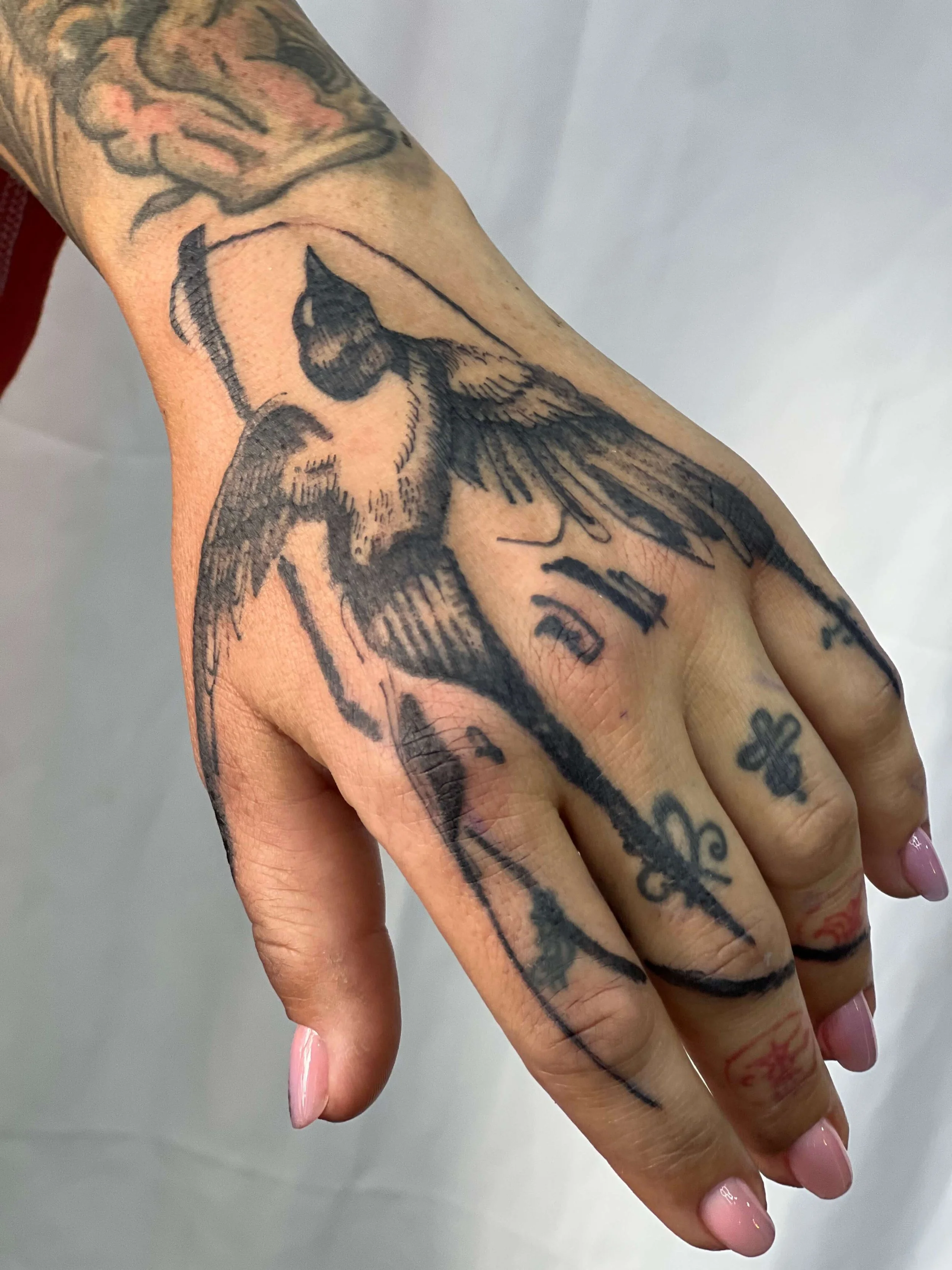 Blackwork tattoo featuring a bird in bold illustrative composition.