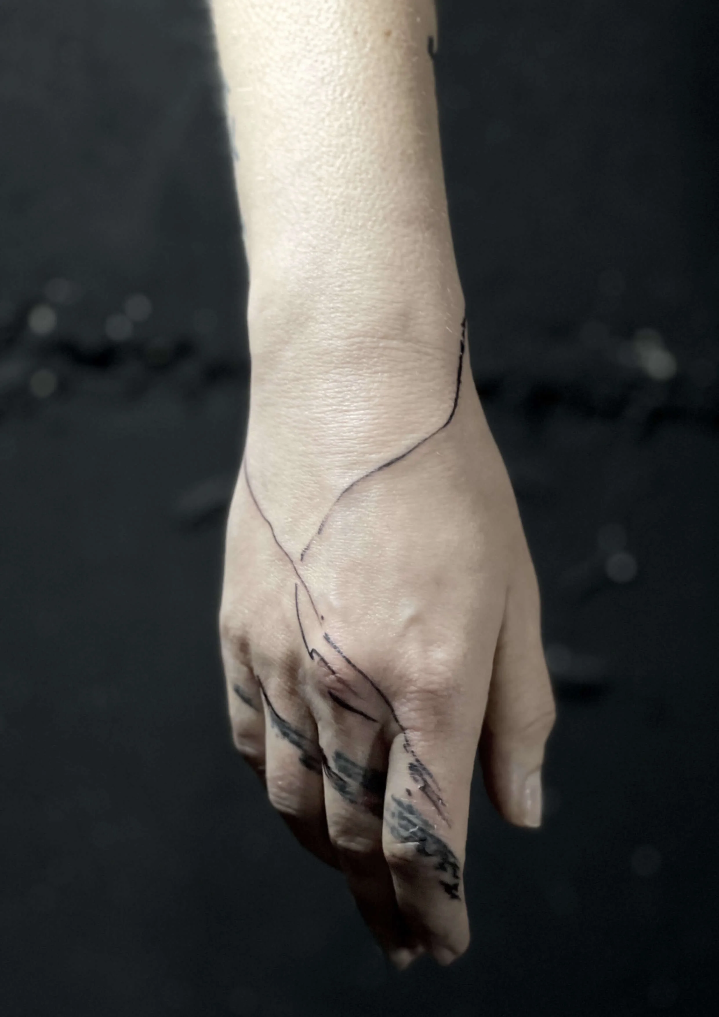 Minimal black ink finger tattoo with bold linework and shading.