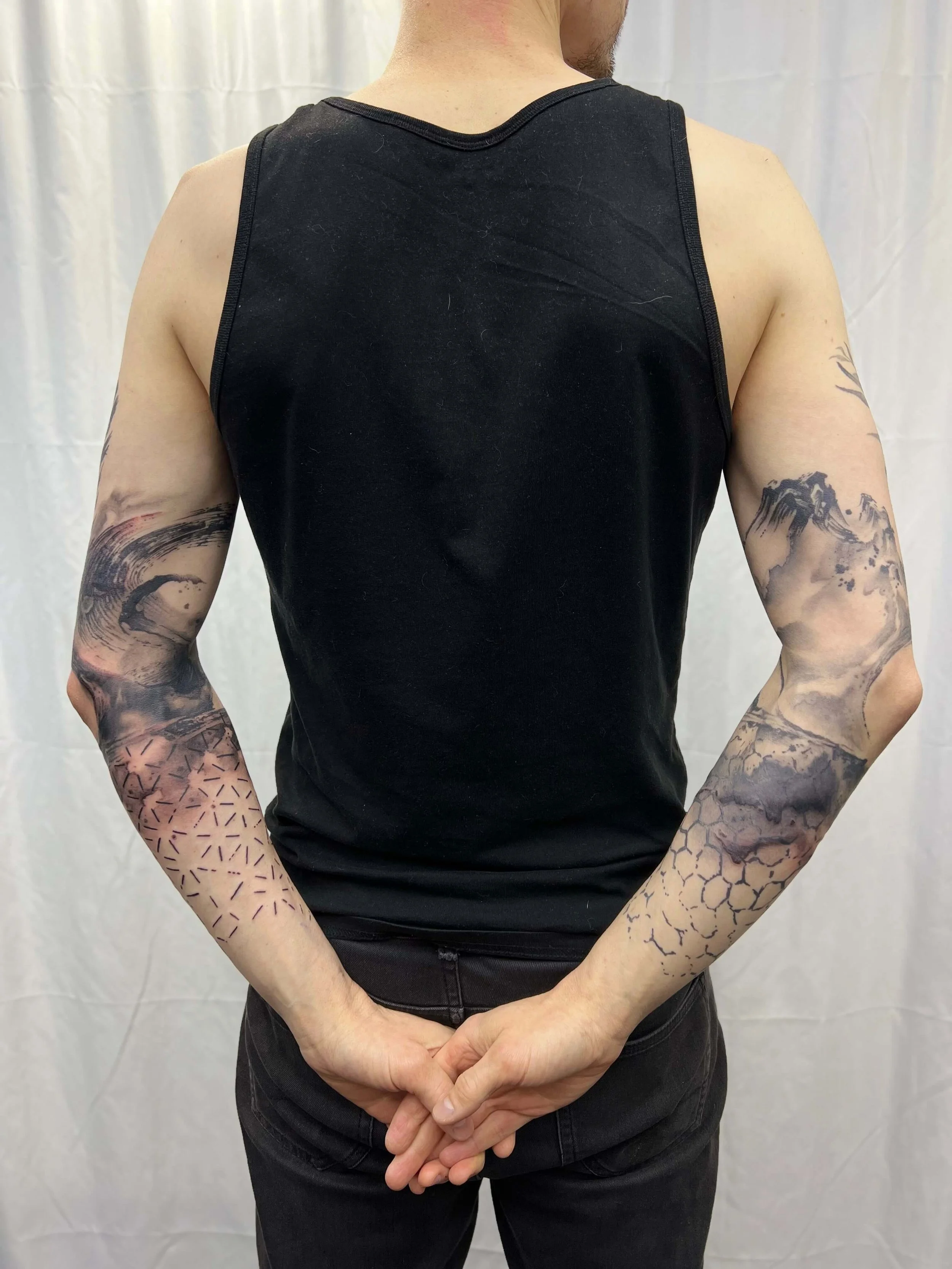Contemporary black ink sleeve combining natural symbolism with structured geometric design.