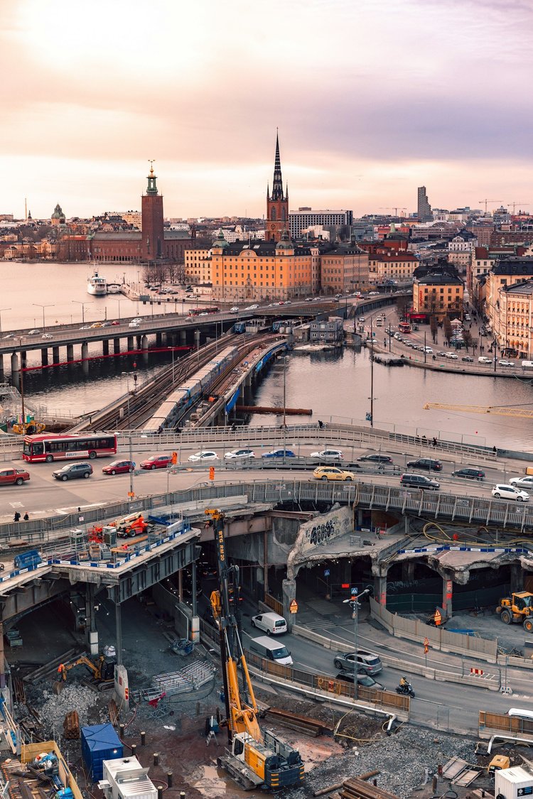 Stort byggprojekt i stadsmiljö med vy över Stockholm