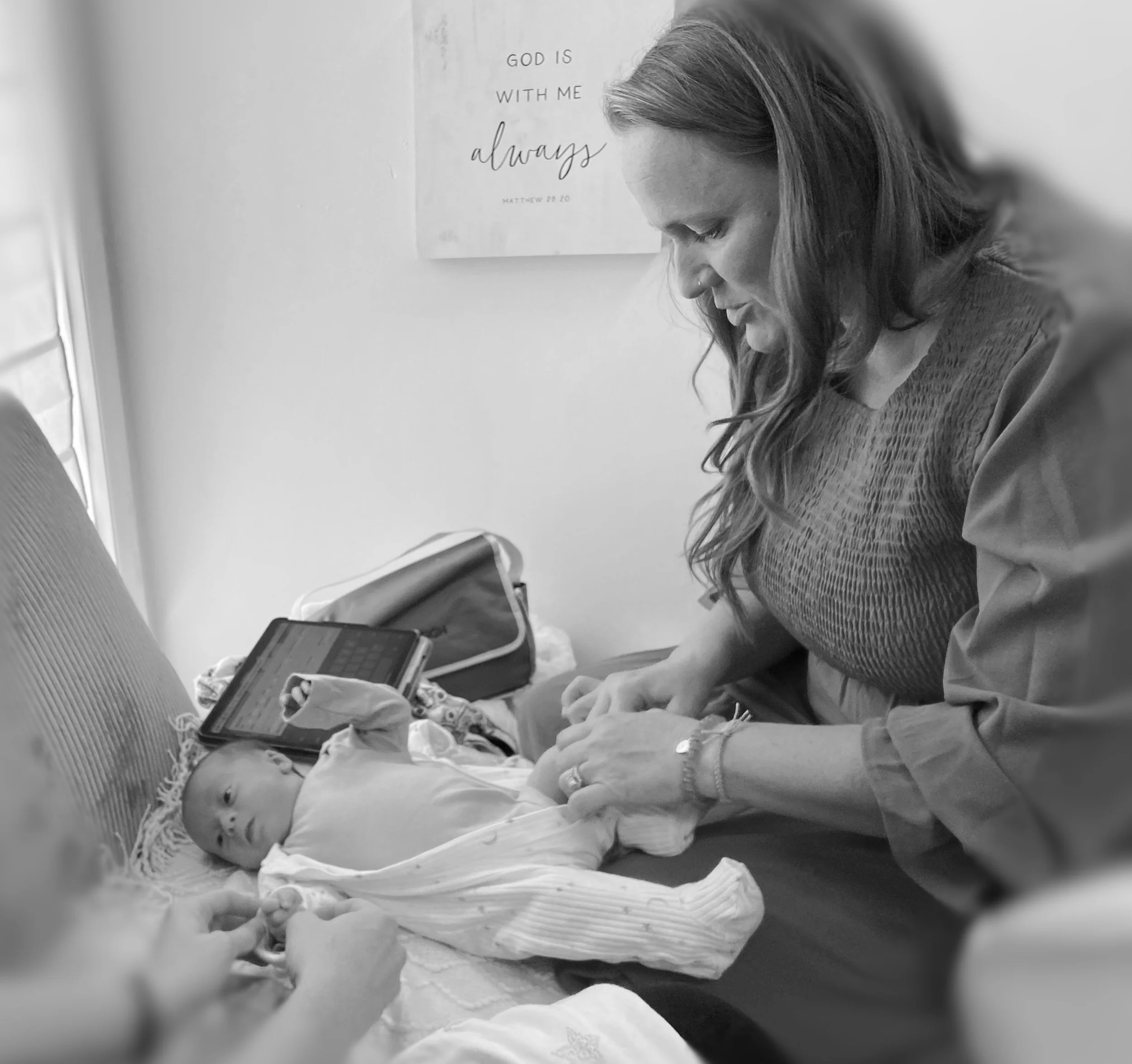 Midwife performing well baby check during postpartum visit.