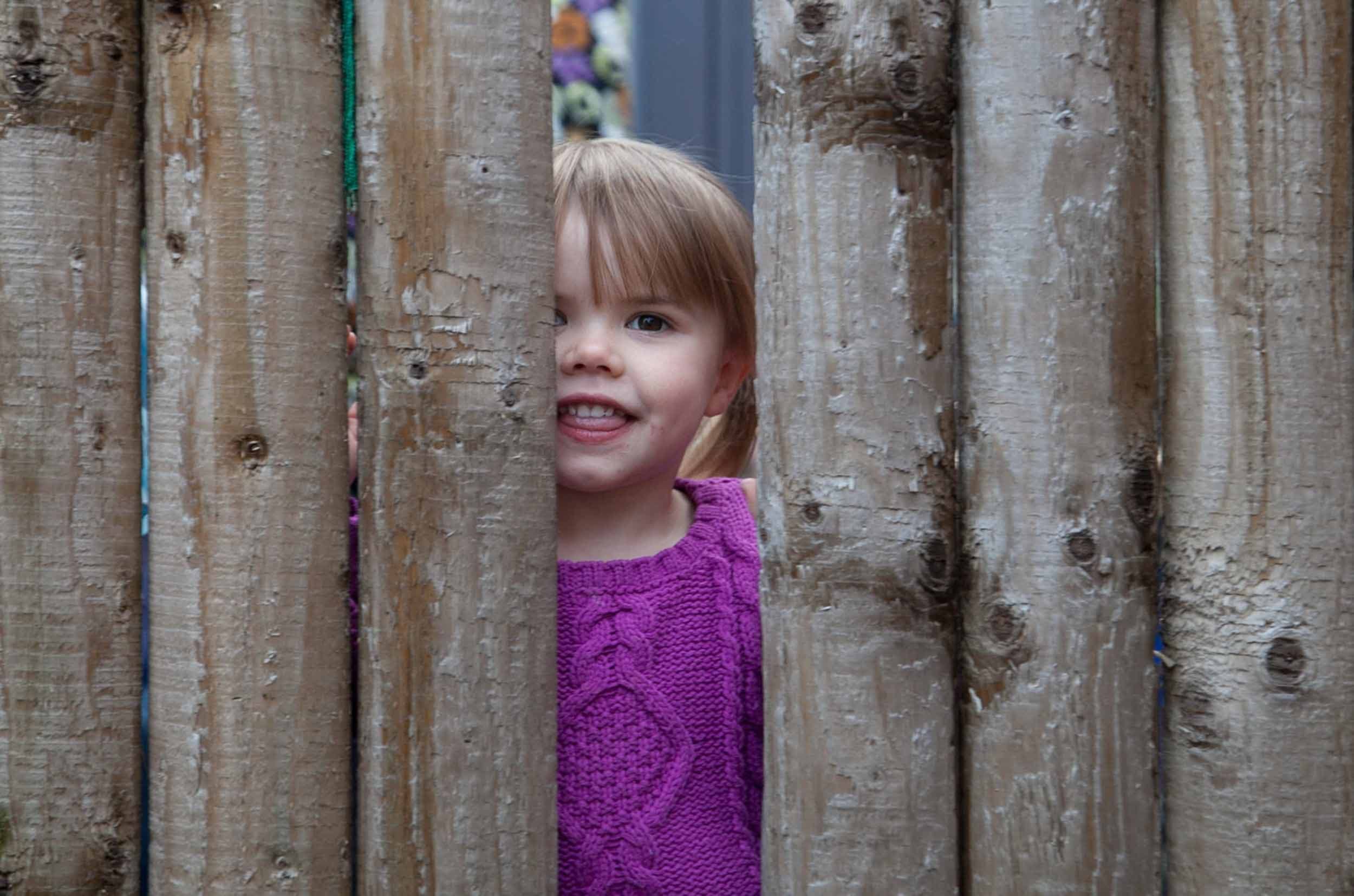 young-girl-peeping-through-fence-cheeky.jpg