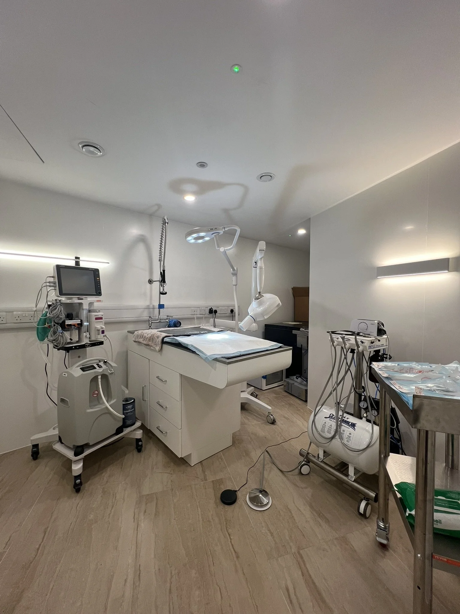 Hospital operating room with medical equipment, examination table, monitors, light, and supplies.