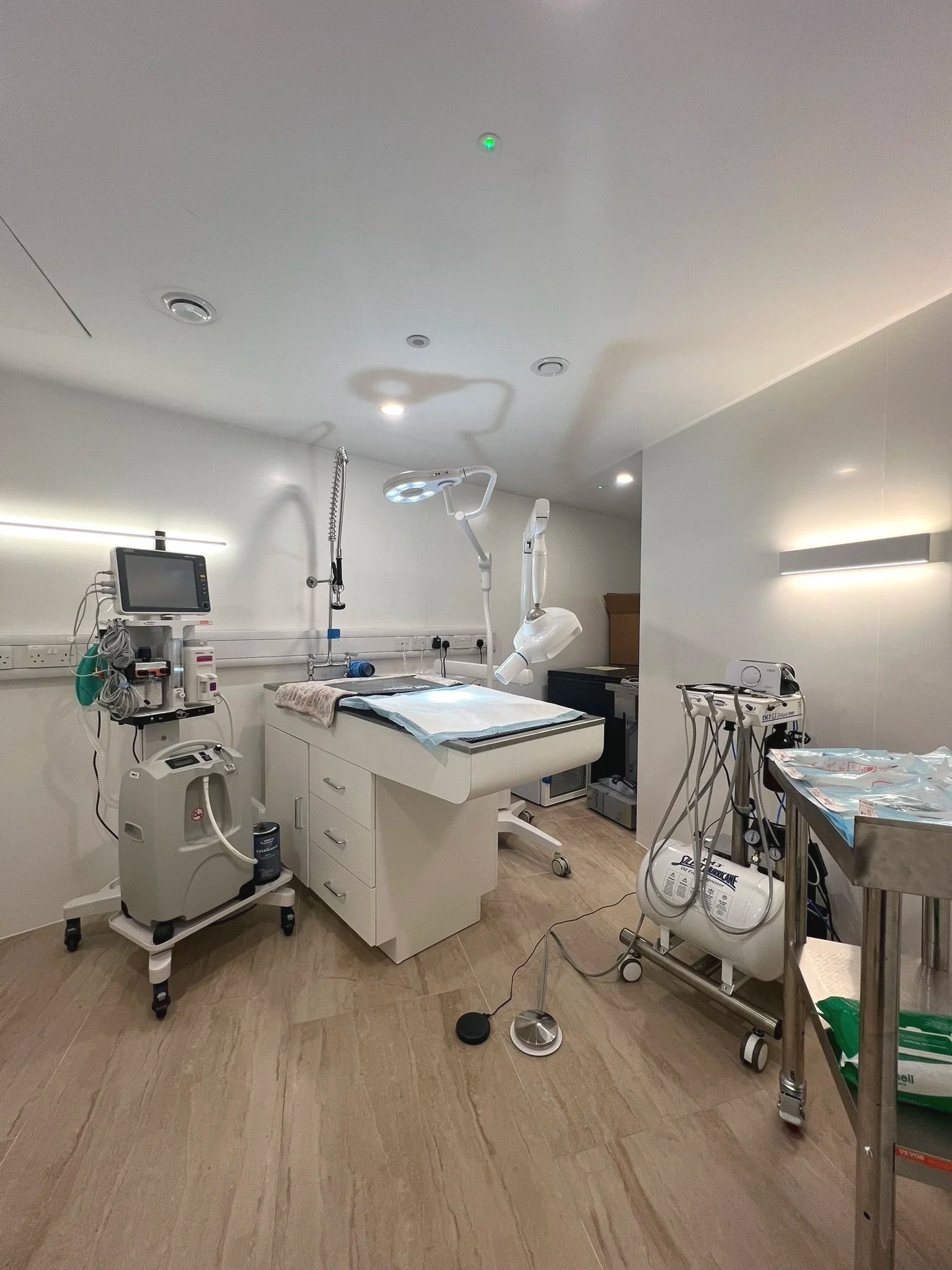 Empty medical examination or operating room with hospital equipment and surgical lights.
