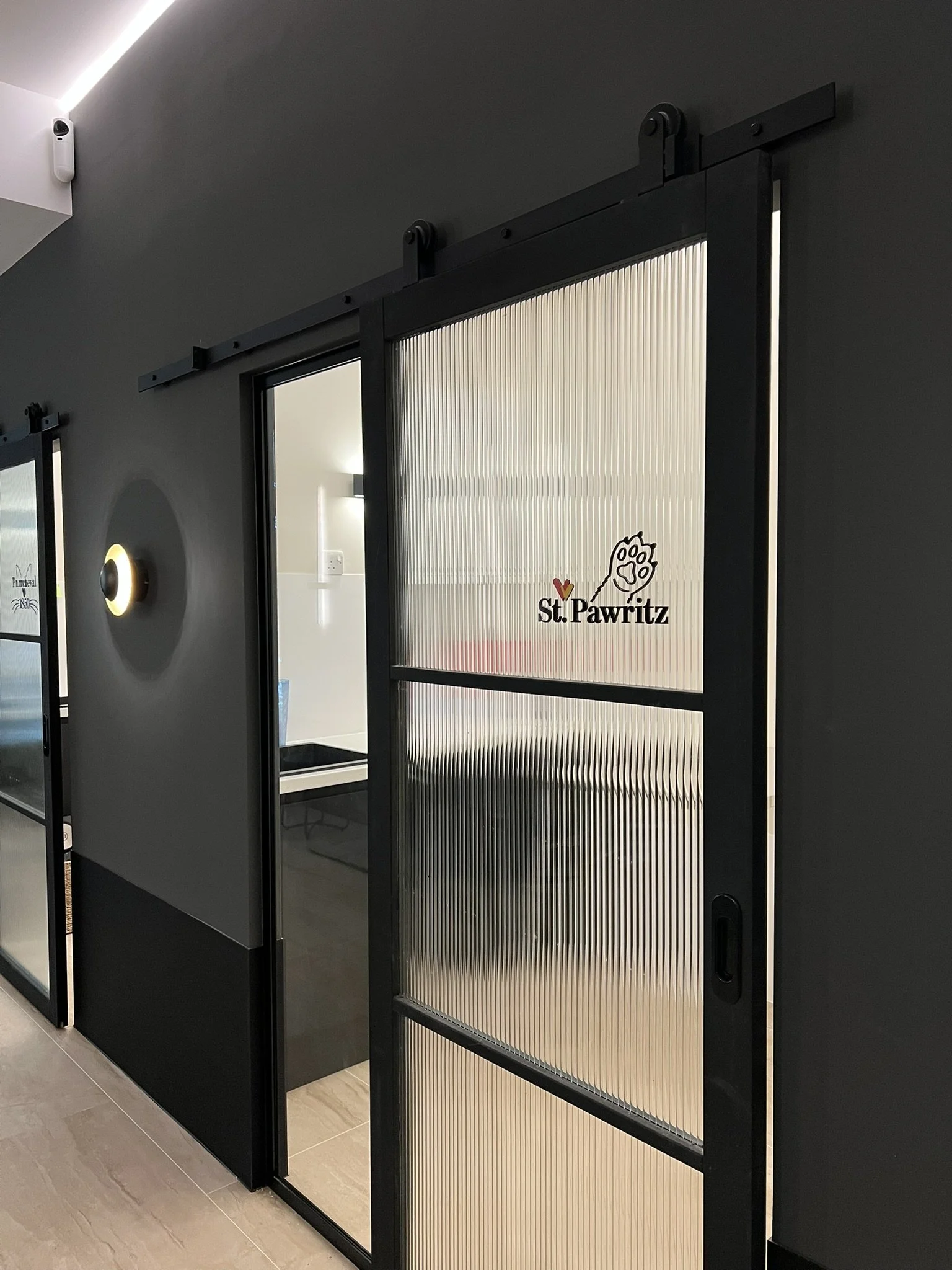 Sliding glass door with frosted glass panels and the words 'St. Pawritz' along with a paw print logo.