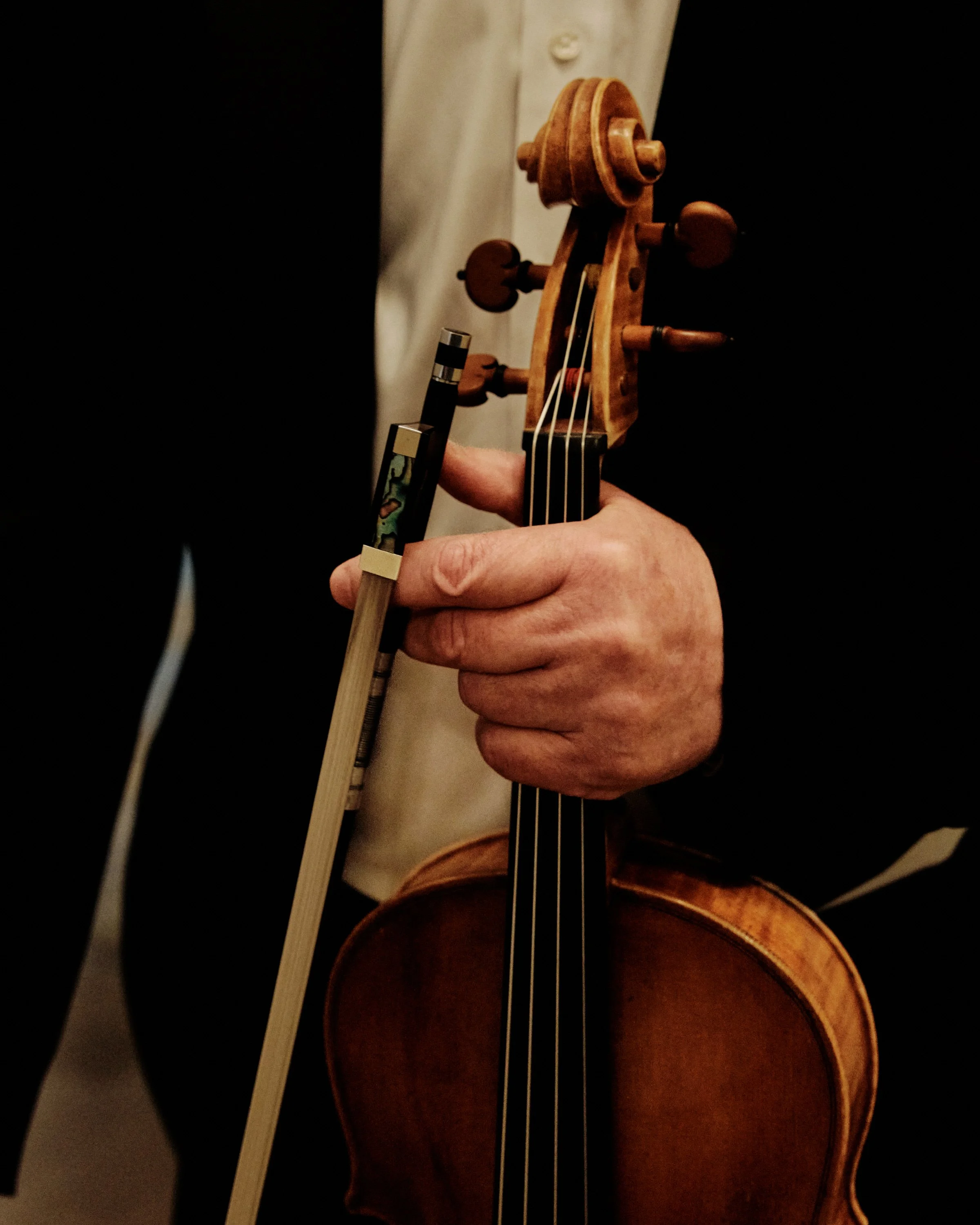 Person spielt Geige mit Bogen.
