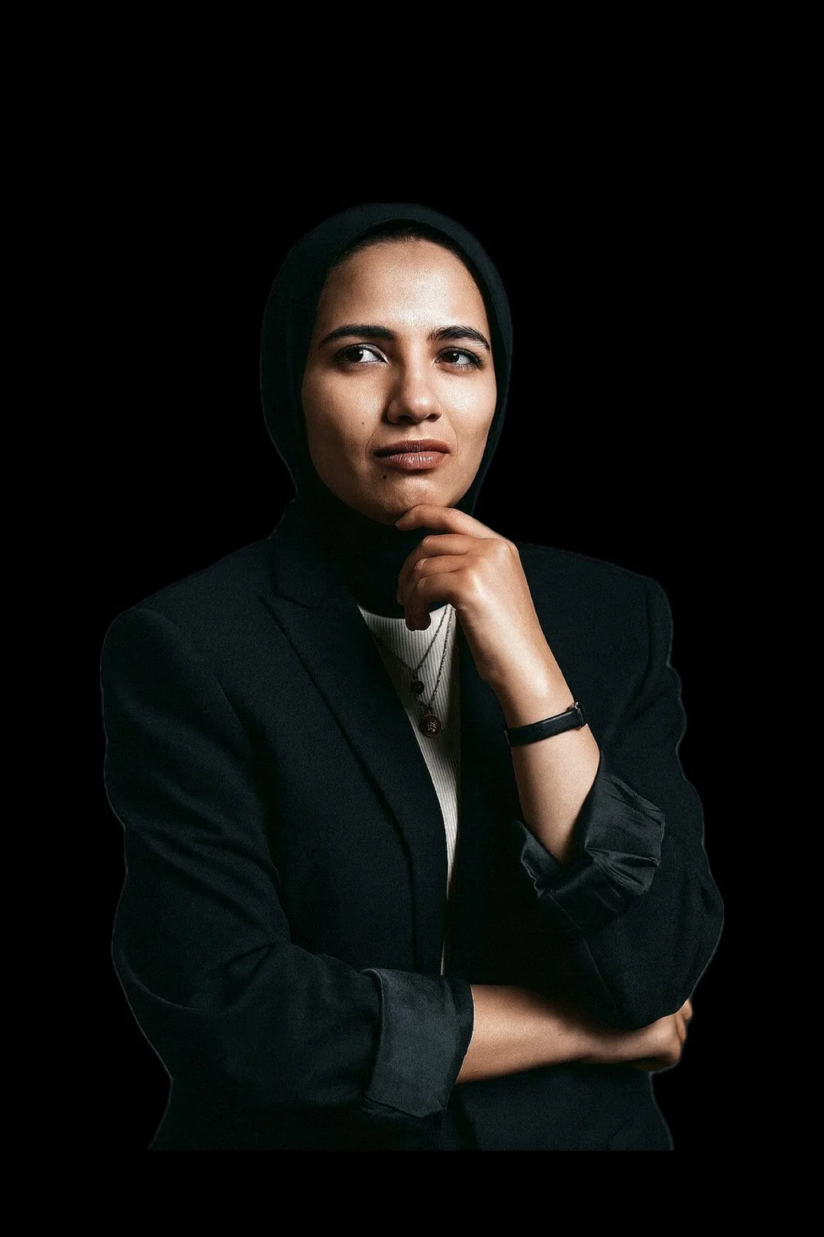 Person wearing glasses and a dark jacket, smiling with arms crossed.