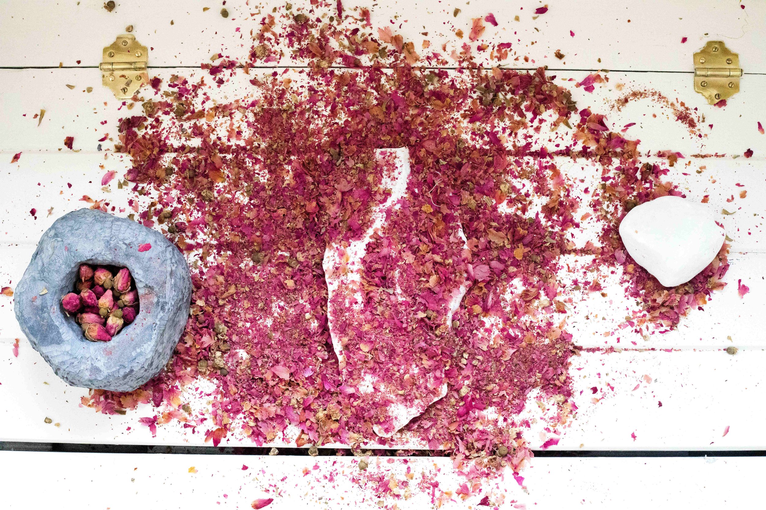 Hush to hear a petal fall, mingle with the earth, 2026, Rose petals, carrara marble, black soapstone, Dimensions variable