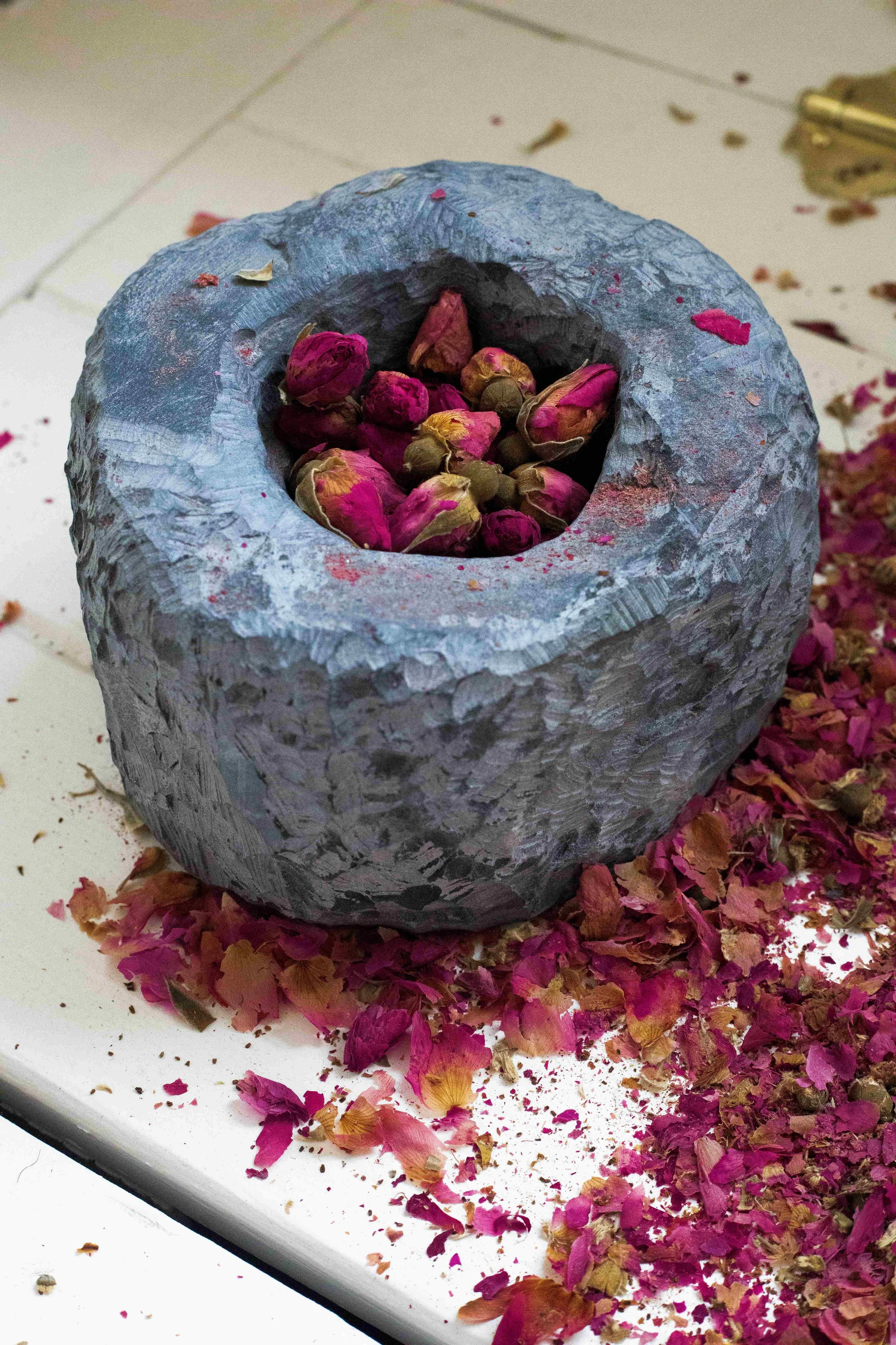 Hush to hear a petal fall, mingle with the earth, 2026, Rose petals, carrara marble, black soapstone, Dimensions variable