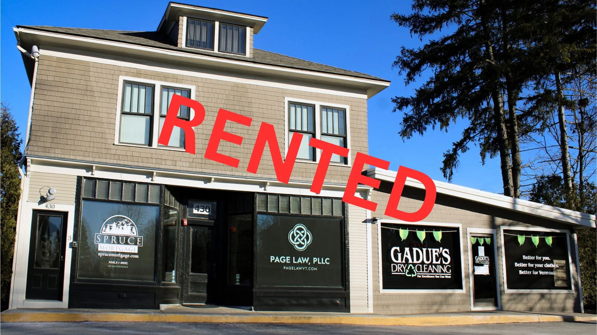 Building with storefronts for Spruce Mortgage, Page Law, and Gadue's Dry Cleaning.