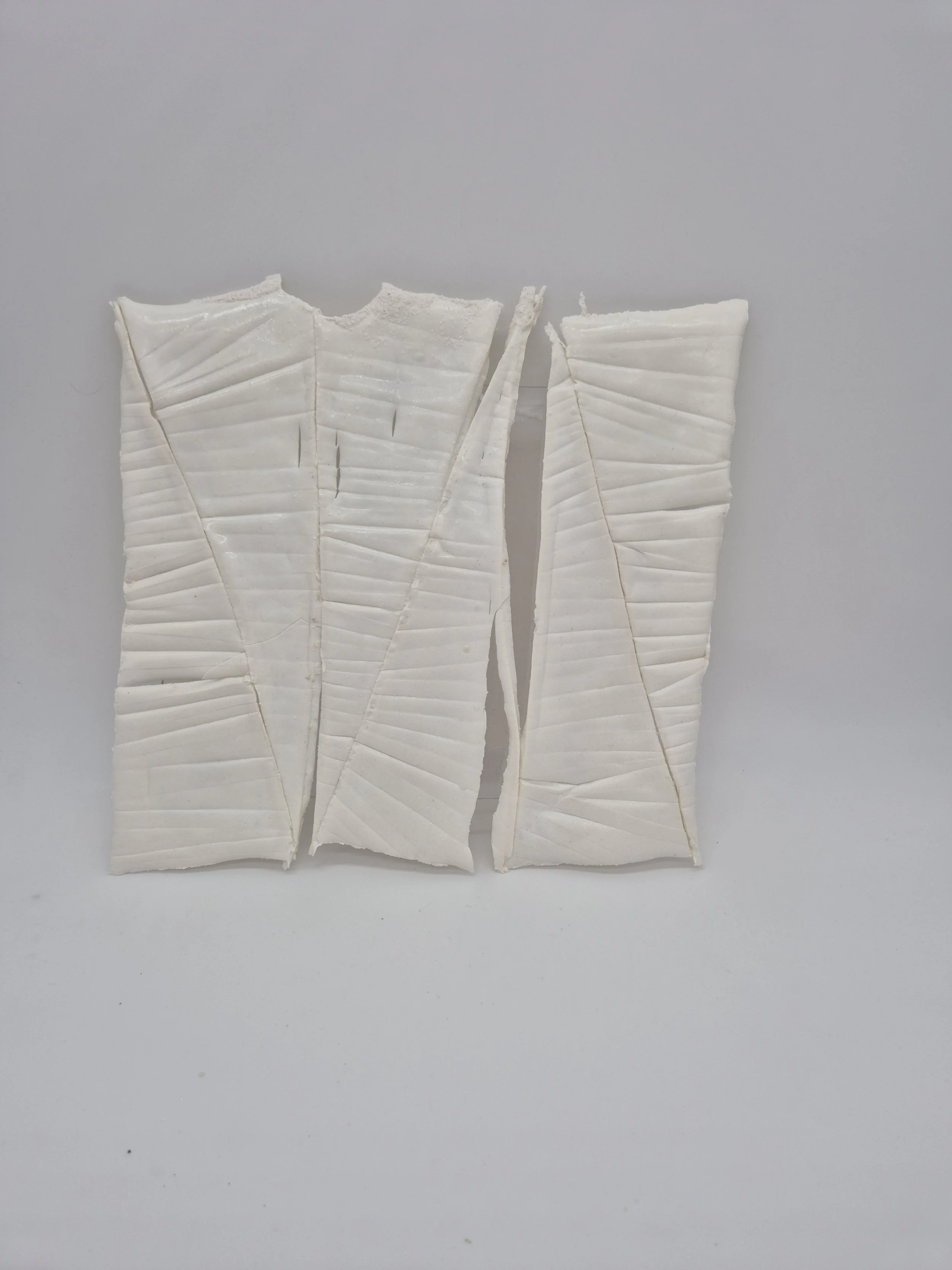 Abstracte kunst met witte, gestructureerde panelen op een lichte achtergrond.