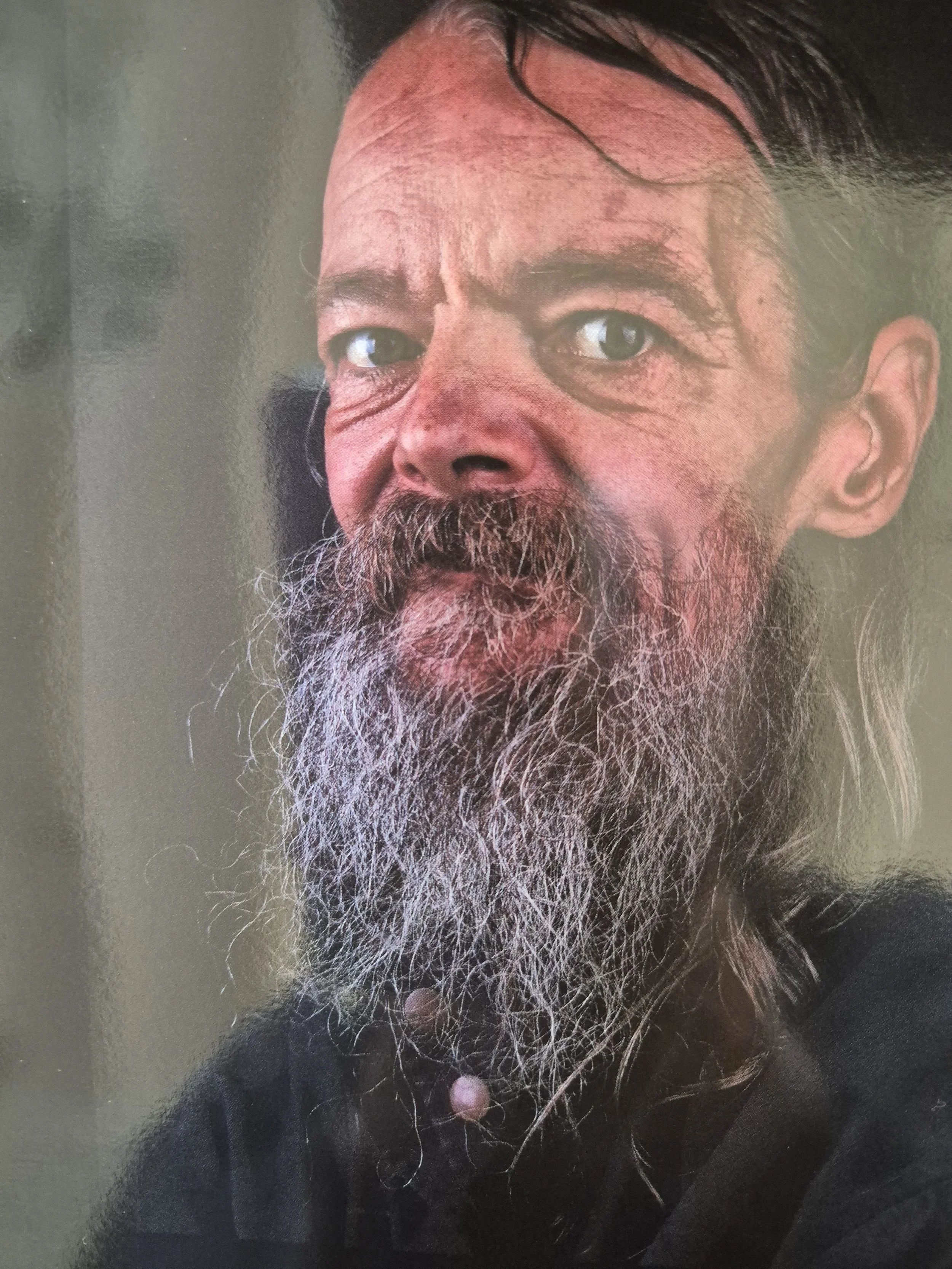 Portret van een man met een lange grijze baard en lang haar. Rotterdamse dak- en thuisloze.