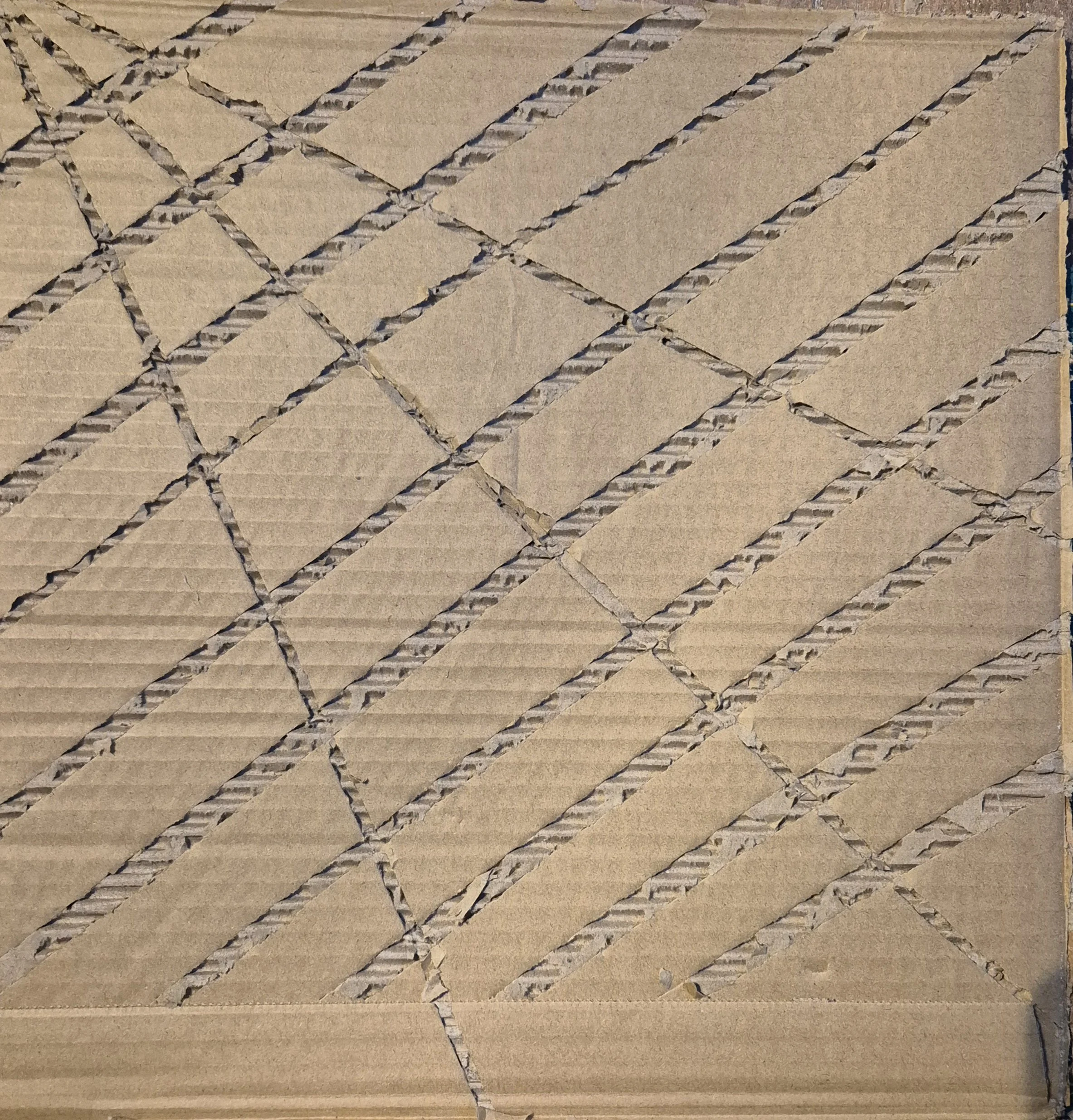 Kartonnen doos met diagonale snedes en gescheurd oppervlak.