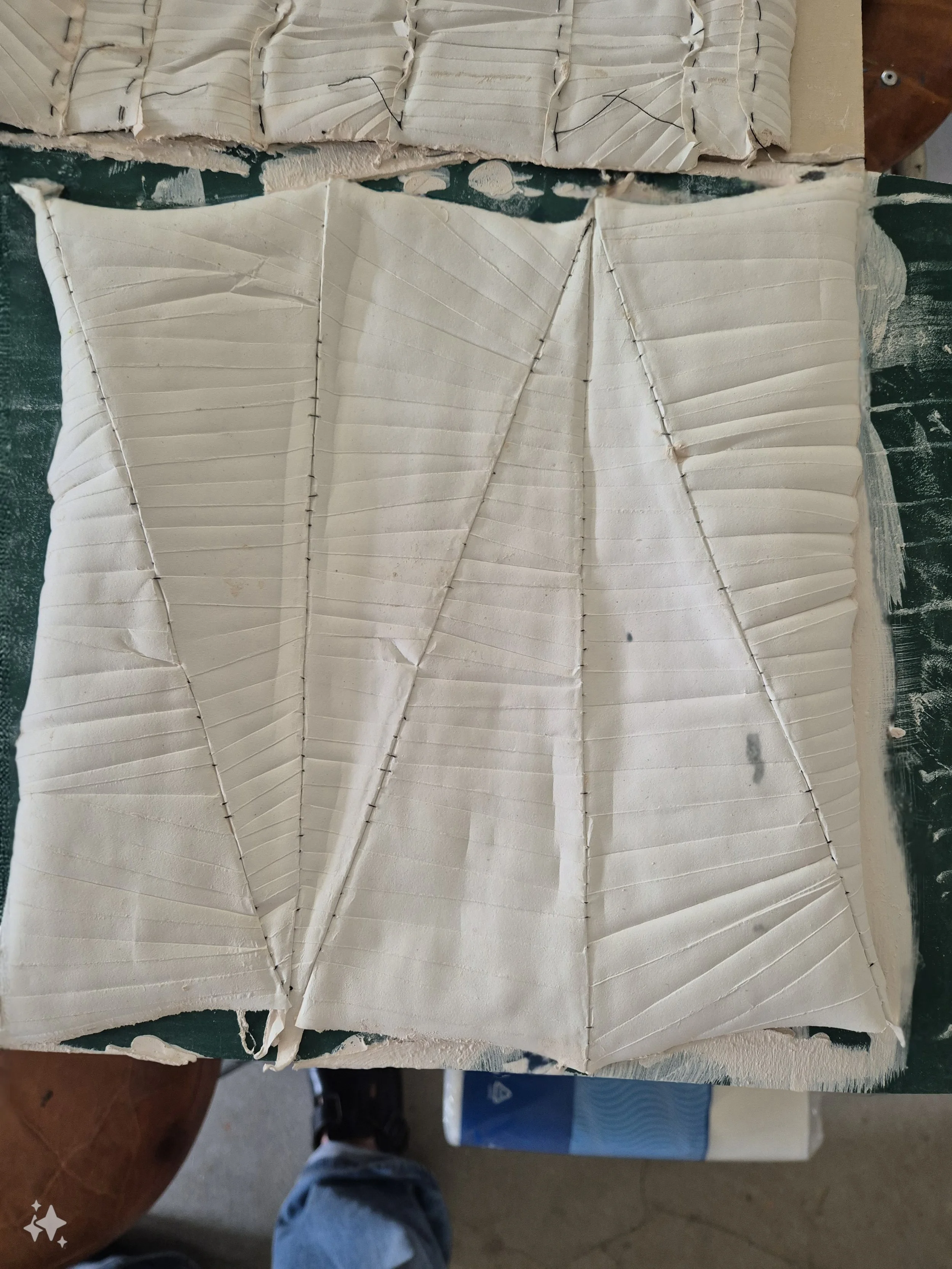 Textiel met geometrische patronen en plooien op een oppervlak.