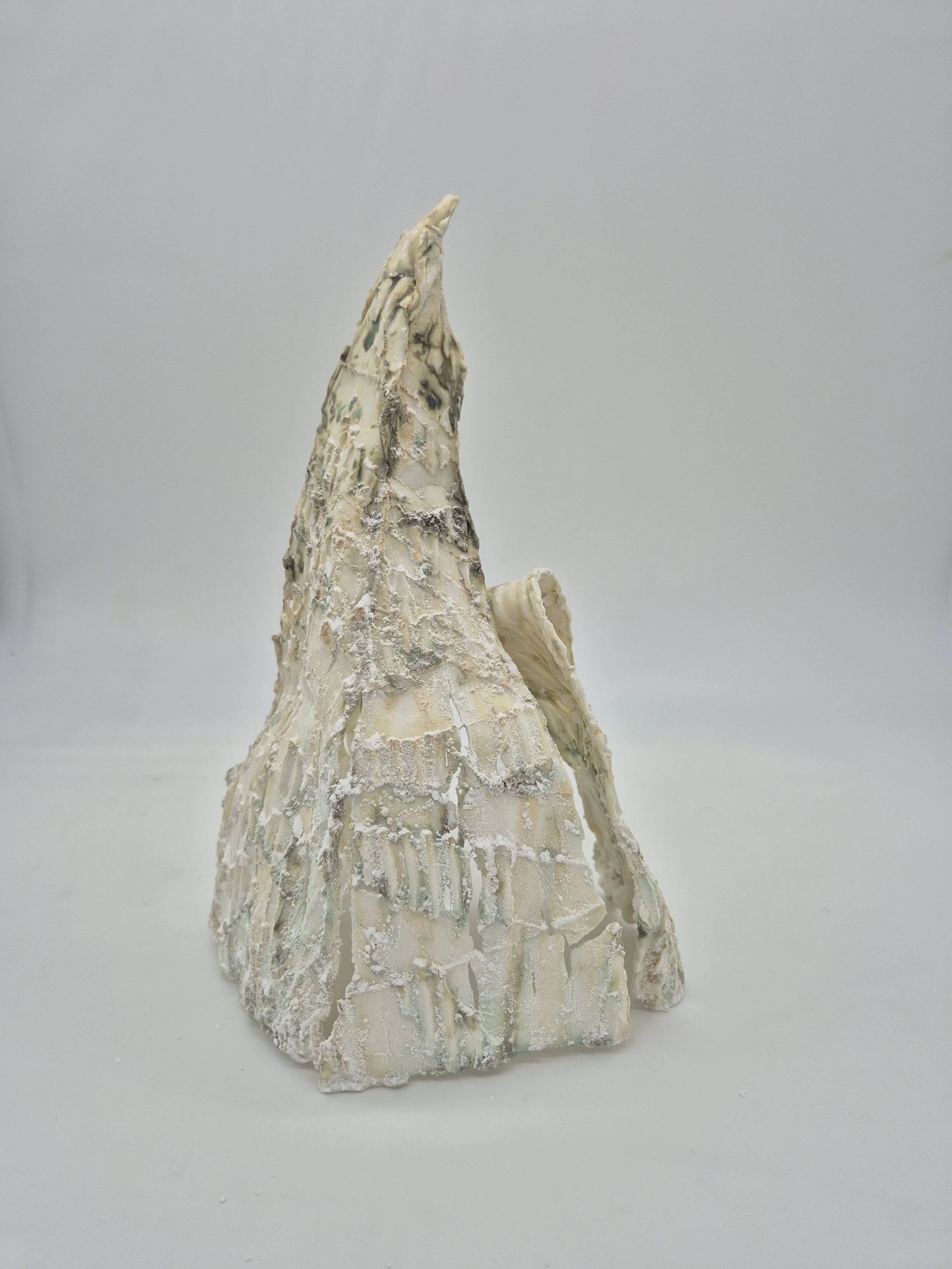 Abstracte kleisculptuur met ruwe textuur, bijnaam bergvormig, op een witte achtergrond.