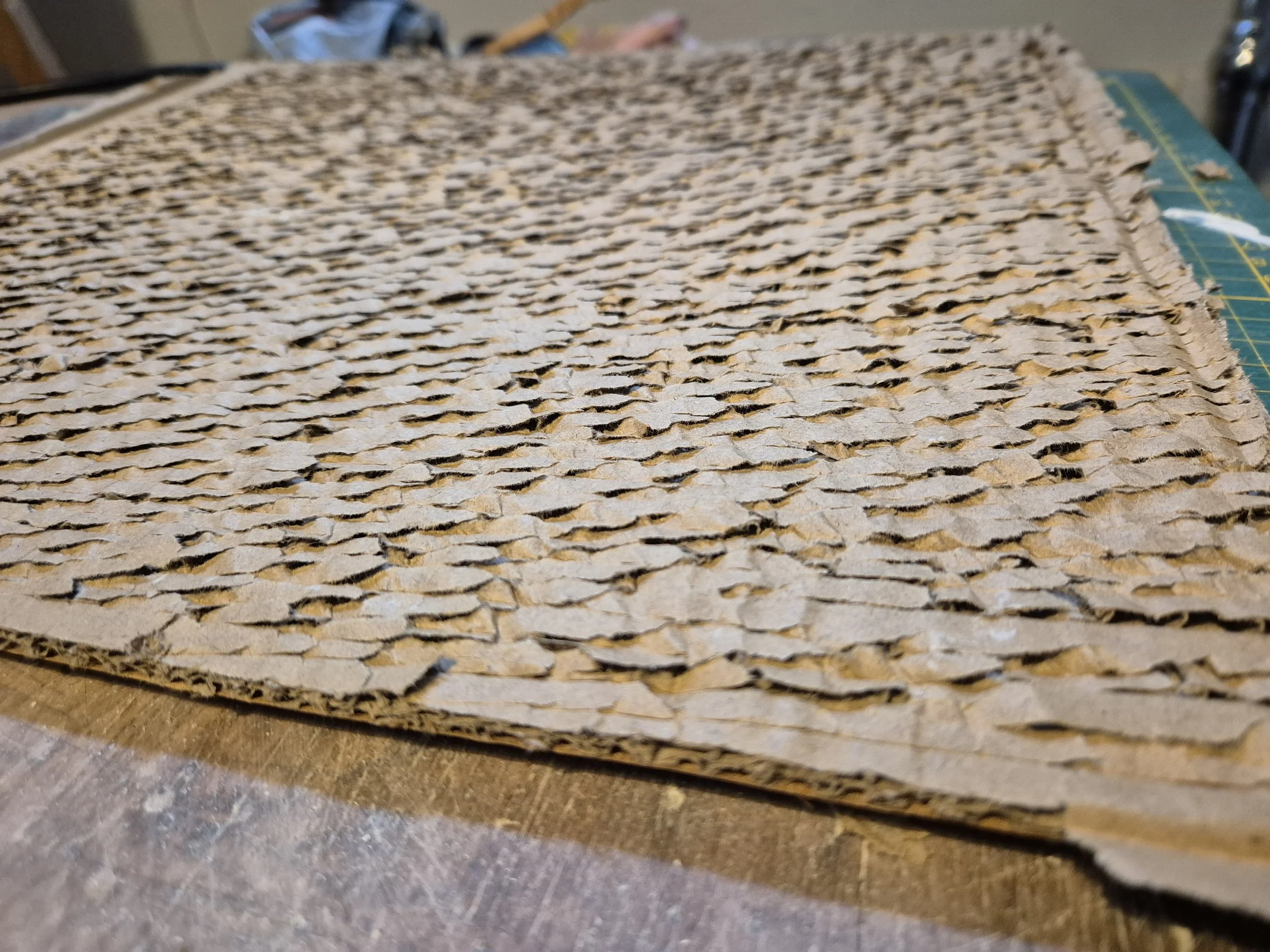 Een stuk golfkarton met gescheurd oppervlak op een tafel.