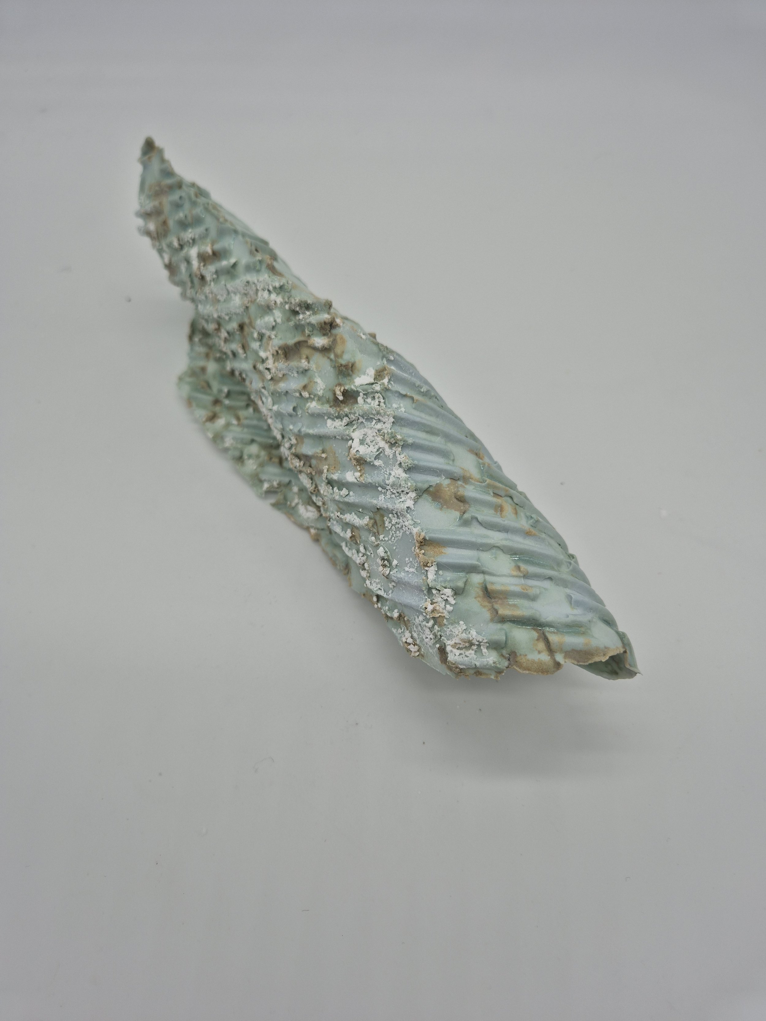 Een abstract kunstwerk met een geribbelde kopergroene textuur, gemaakt met karton