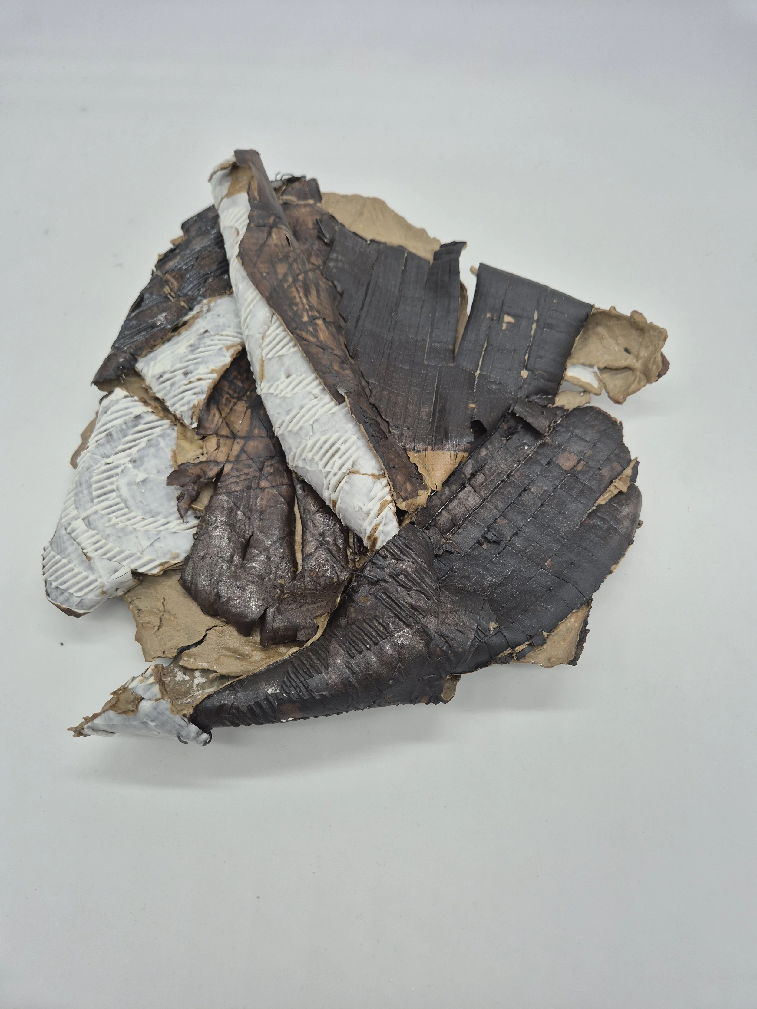 Keramiek kunstwerk dat lijkt op gebroken en verkoolde stukken hout