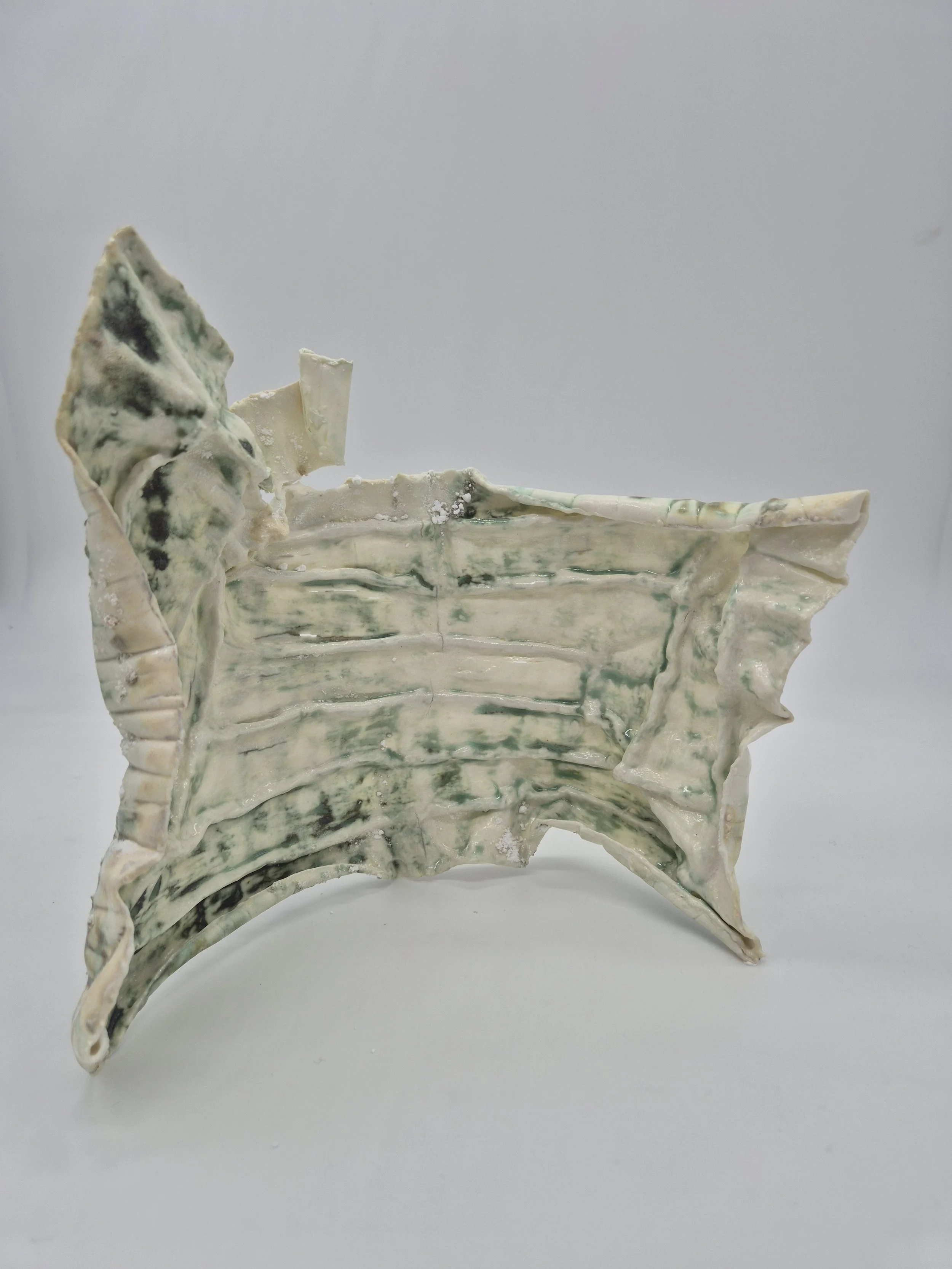 Abstracte keramische sculptuur met witte en groene tinten op een witte achtergrond.