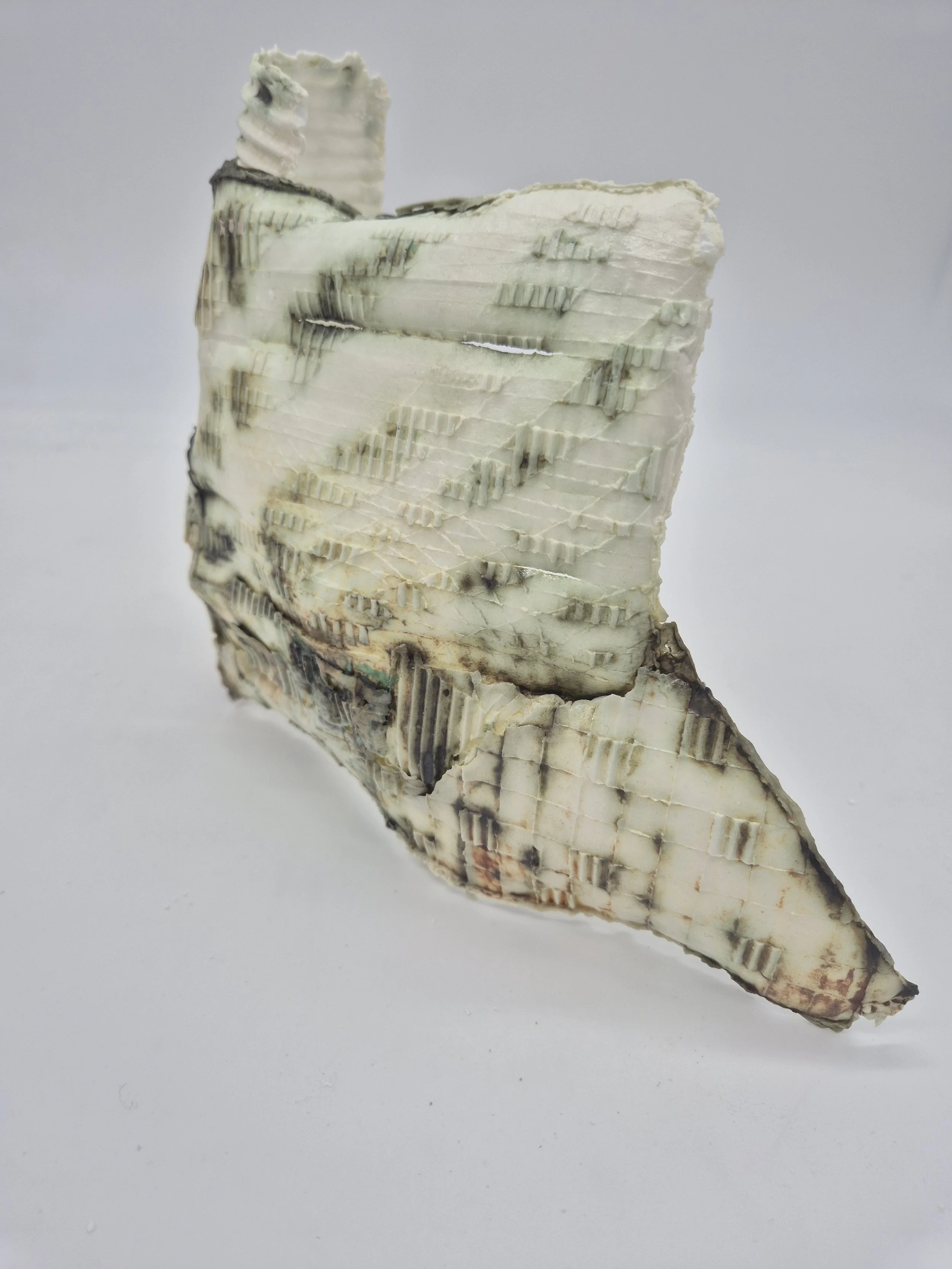 Abstract keramisch kunstwerk met een textuur van gestreepte patronen en verschillende kleuren, voornamelijk wit en zwart.