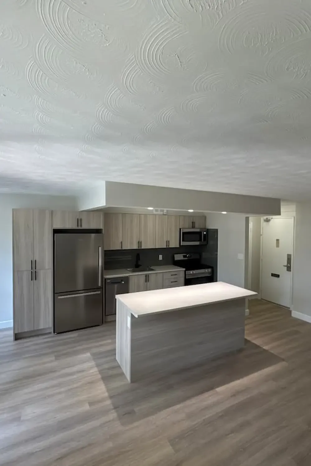 Open concept kitchen remodel featuring wood-textured cabinetry and gray kitchen island.