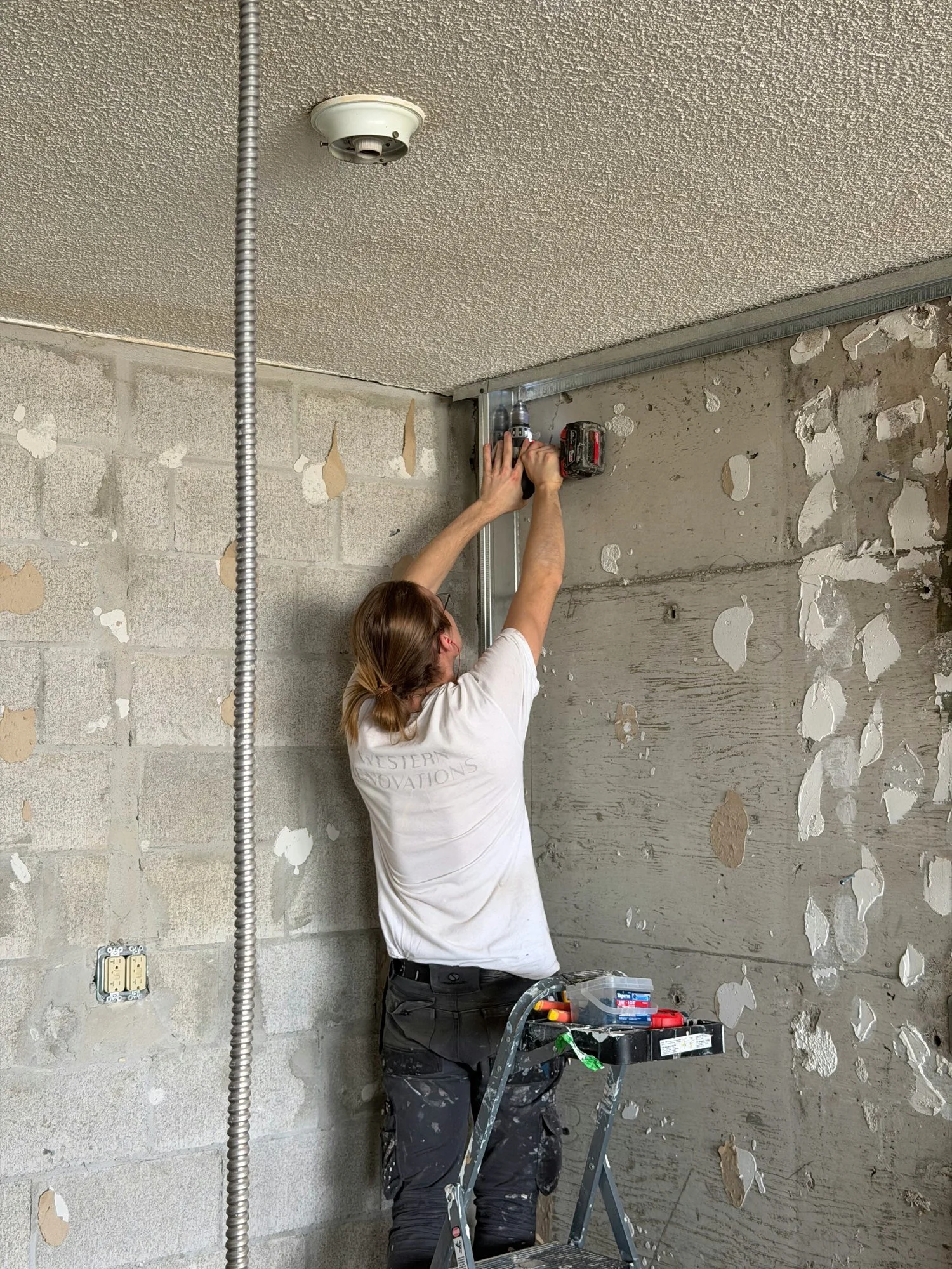 worker-drilling-steel-track-block-wall-windsor-ontario-01.jpg