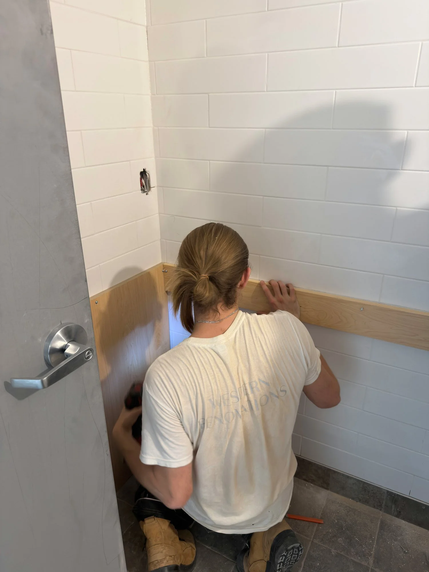 worker-installing-wood-kitchen-cabinet-trim-windsor-ontario-01.jpg