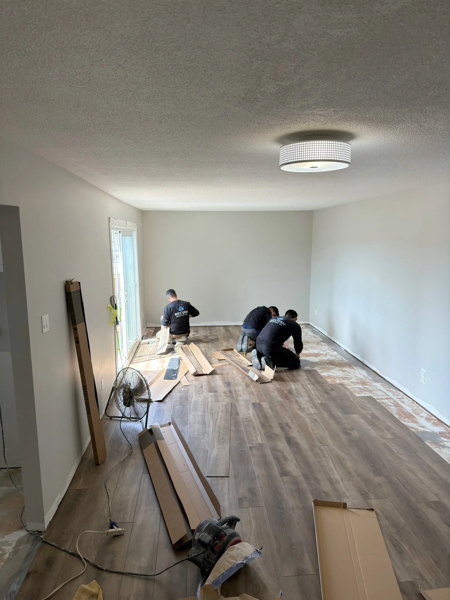 workers-installing-plank-flooring-living-room-london-ontario-01.jpg