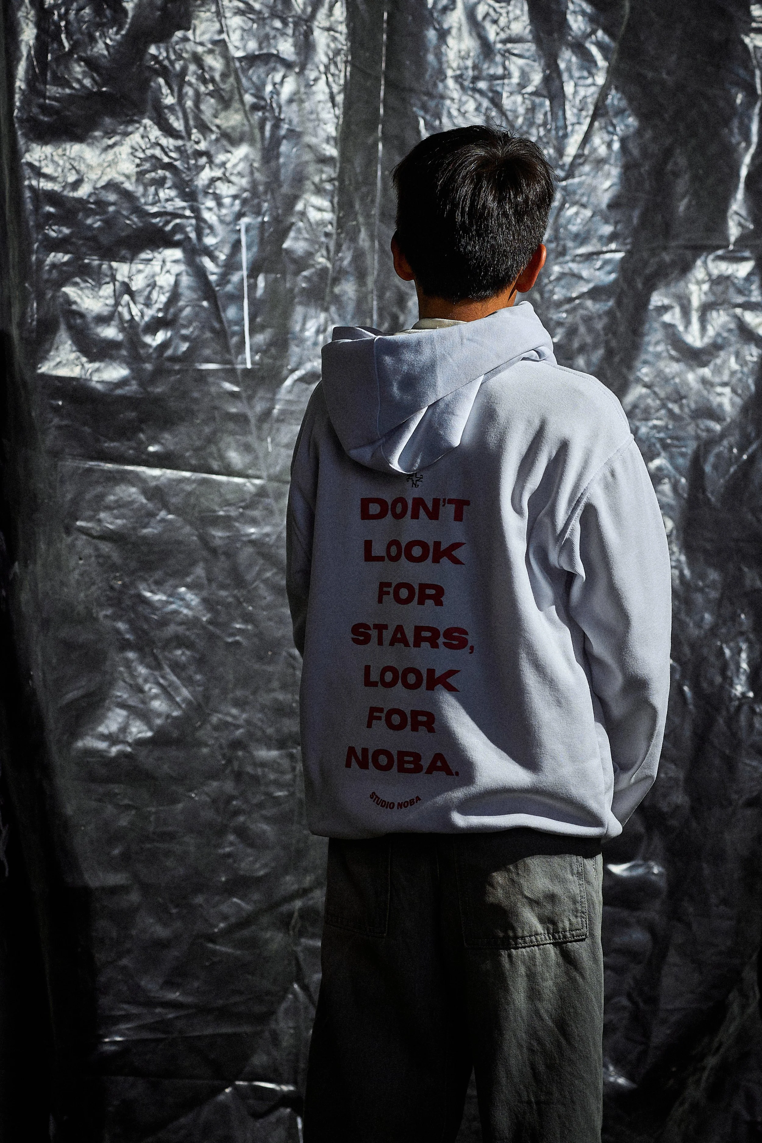 Person wearing hoodie with text 'Don't look for stars, look for Noba.'