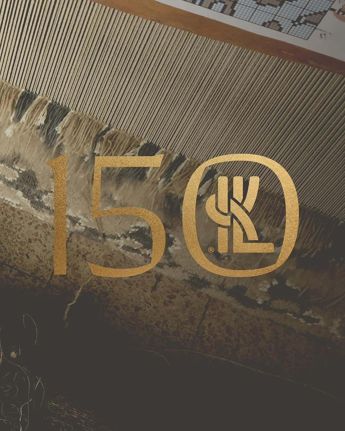 Gold logo with the number 150 and a stylized 'K' inside a circle, overlaying an image of a woven rug, a stone-like surface, and a wooden table with a product card on top.