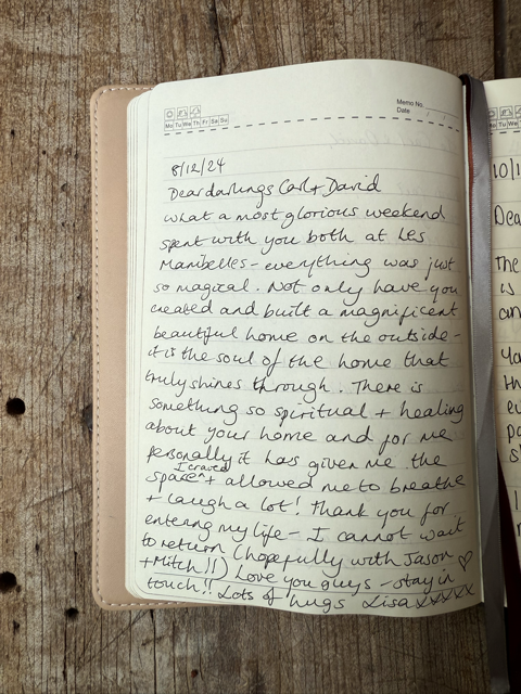 Open journal with handwritten notes on a wooden surface.