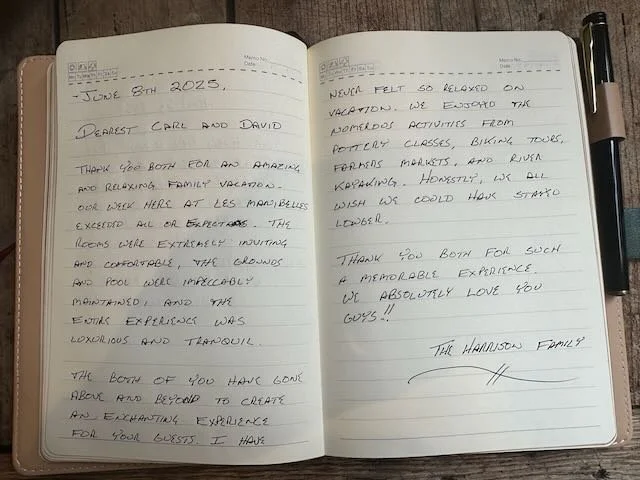 Open journal with handwritten notes about a family vacation posted on June 8th, 2023, expressing gratitude and enjoyment of the experience.