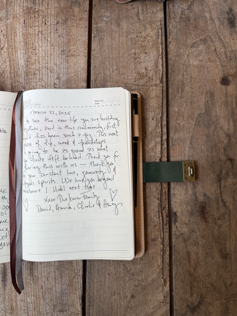 Open notebook with handwritten message on a wooden surface