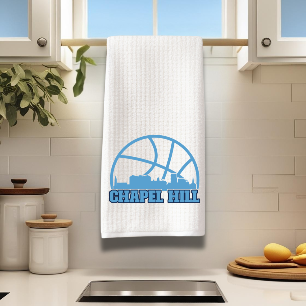 Chapel Hill basketball kitchen towel hanging in modern white kitchen with natural light.