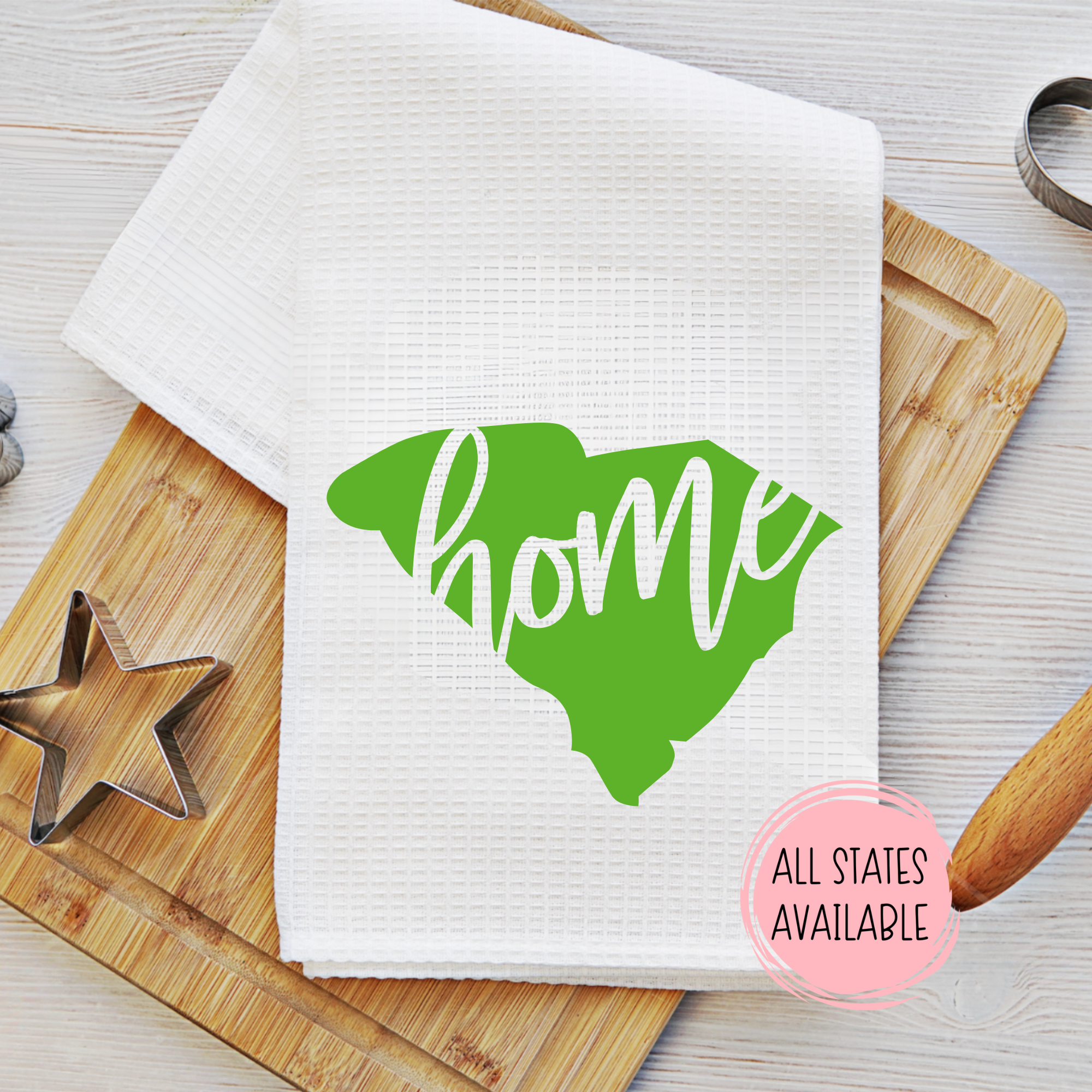 Waffle weave kitchen towel with green South Carolina state home design and baking tools nearby.