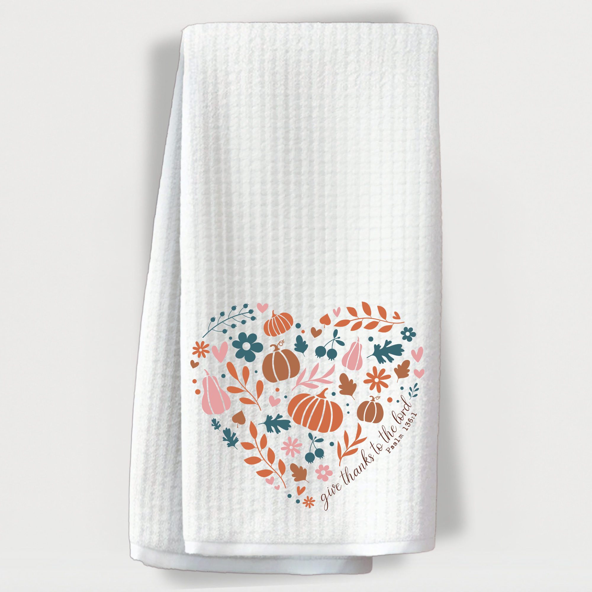 Christian fall kitchen towel with Psalm 136:1 scripture and pumpkin floral heart design on white background.