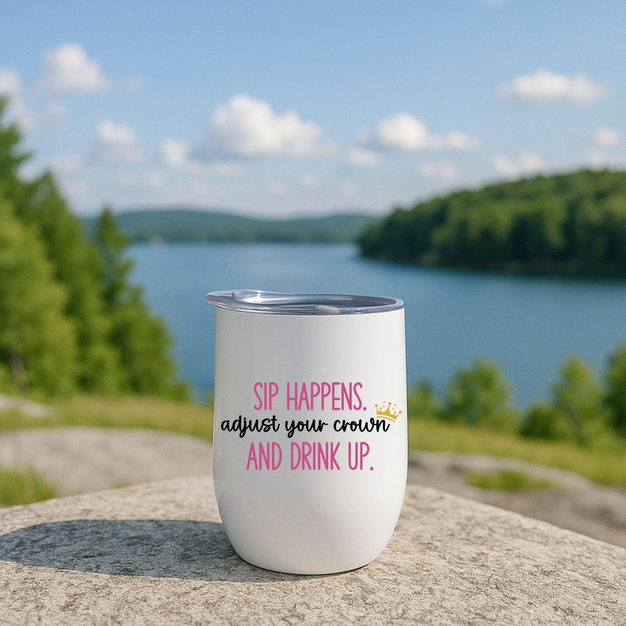 Funny Sip Happens wine tumbler with pink text, outdoors by lake.
