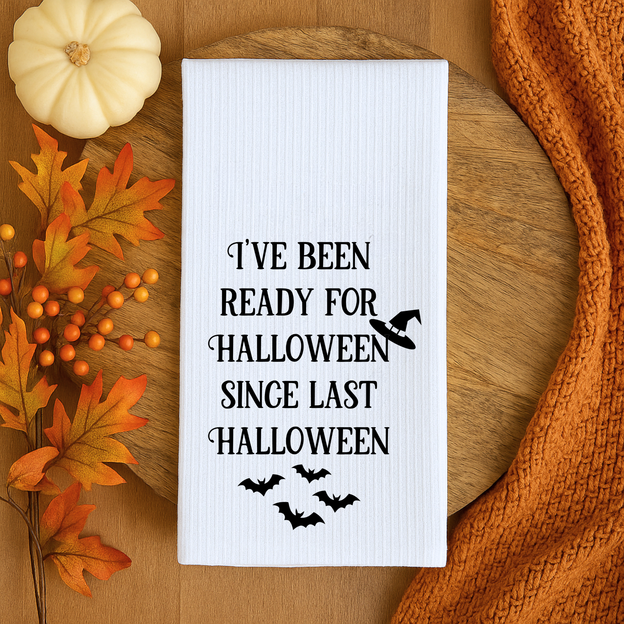 Halloween kitchen towel styled with fall leaves and pumpkin, unique hostess gift.