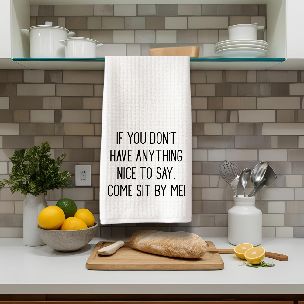 White waffle weave kitchen towel hanging in modern kitchen with quote “If you don’t have anything nice to say, come sit by me.”