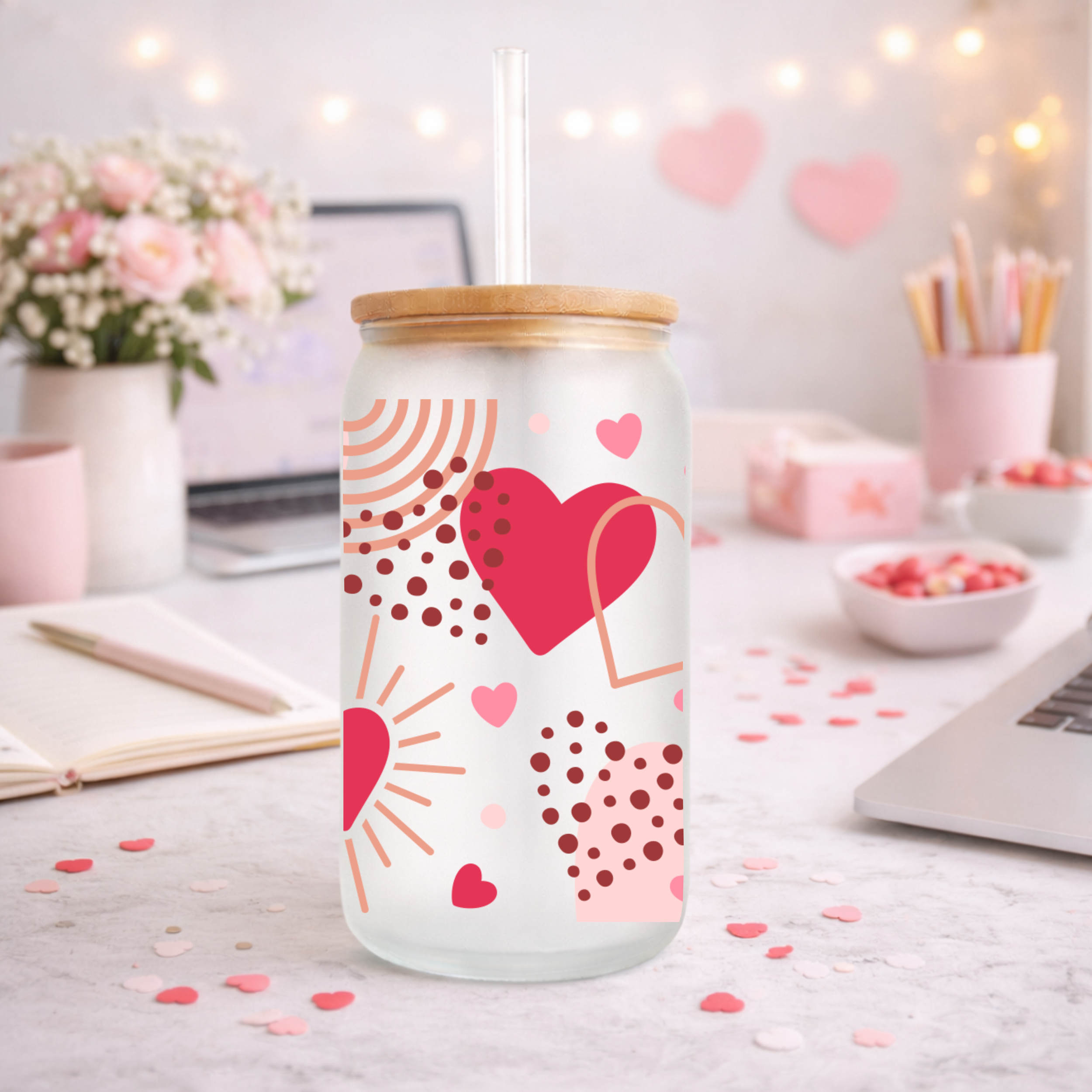 Valentine heart design frosted glass can cup with bamboo lid on a styled desk with laptop, notebook, and soft pink Valentine accents.