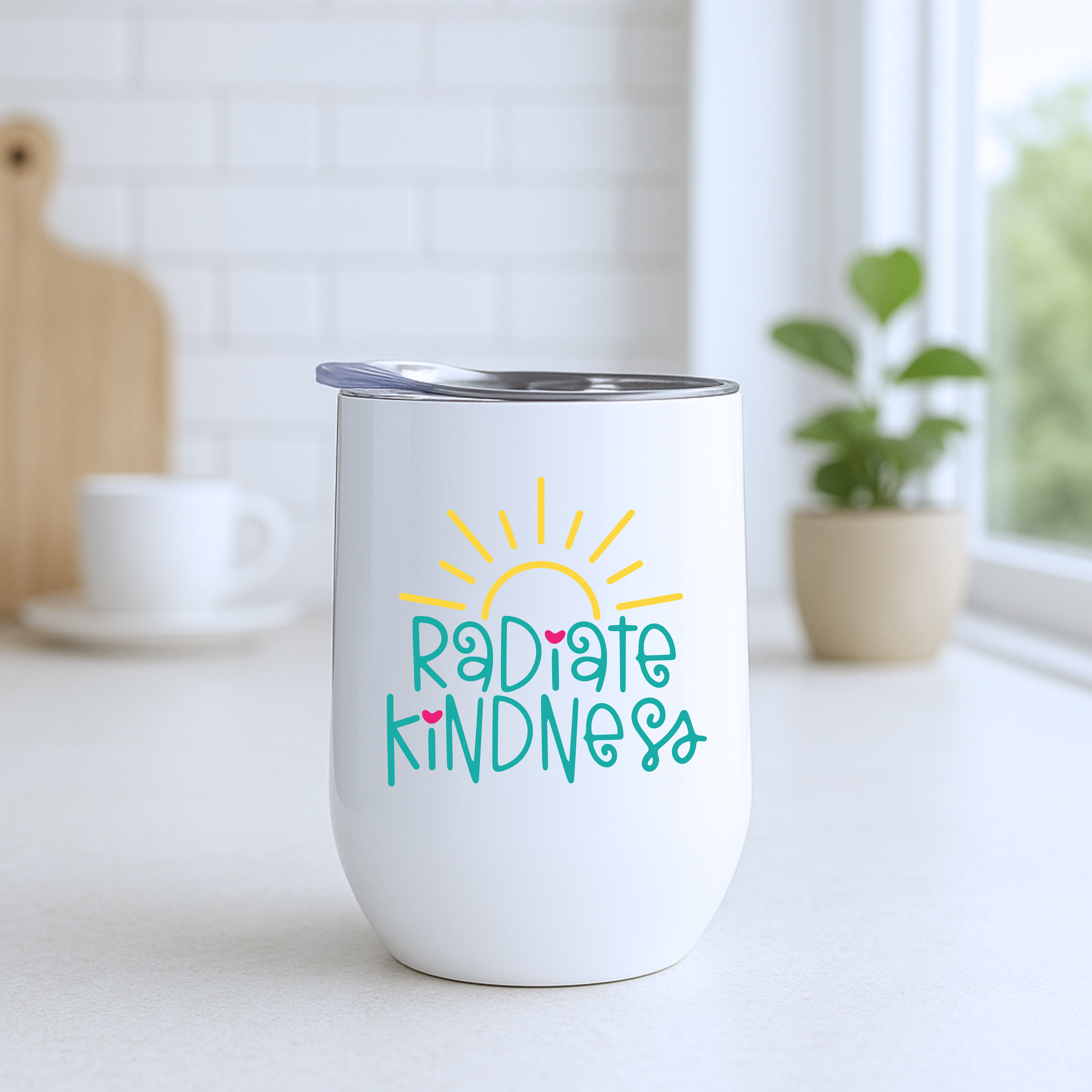 Radiate Kindness insulated wine tumbler on a bright white kitchen counter with modern decor