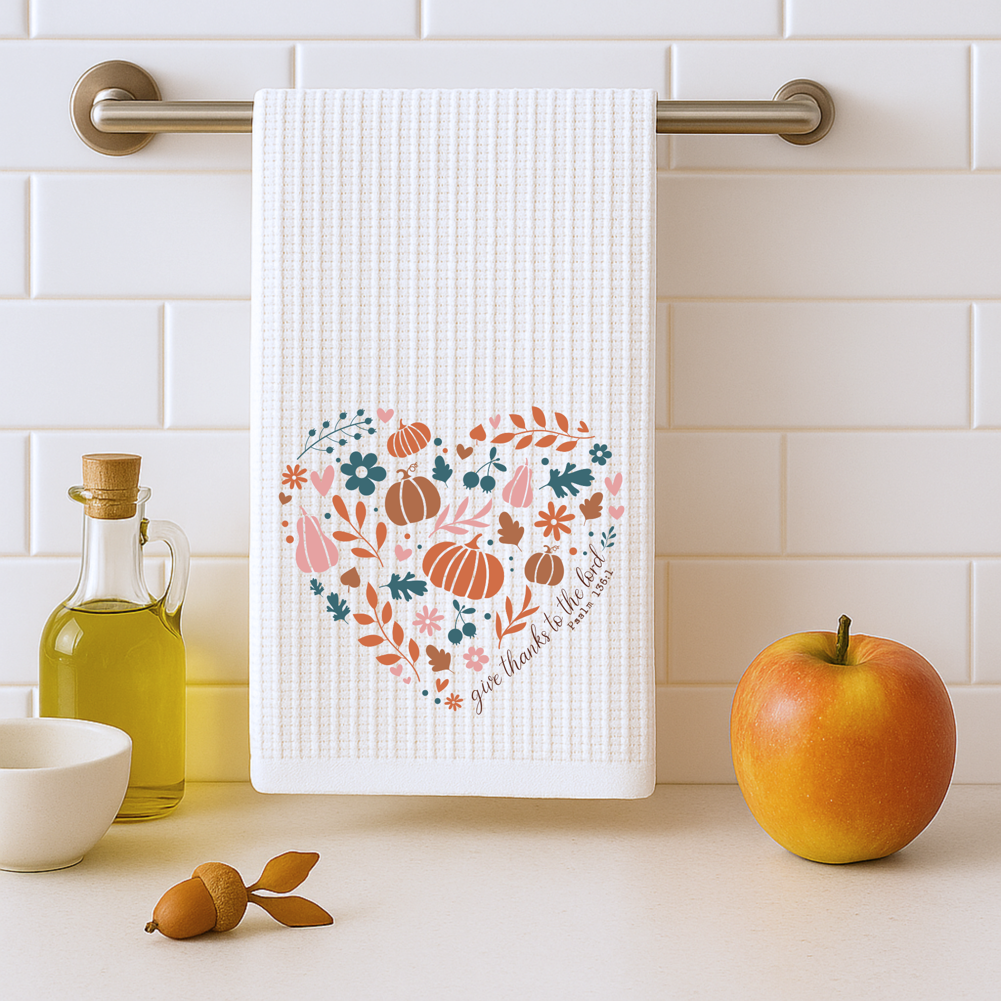Thanksgiving farmhouse kitchen towel hanging on bar in white tile kitchen with apple and olive oil.