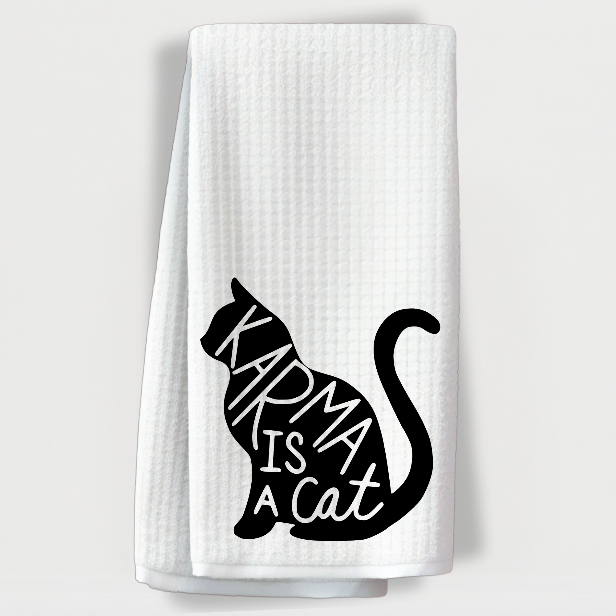 "Waffle towel with black cat graphic and the phrase 'Karma is a cat' in handwritten style font."