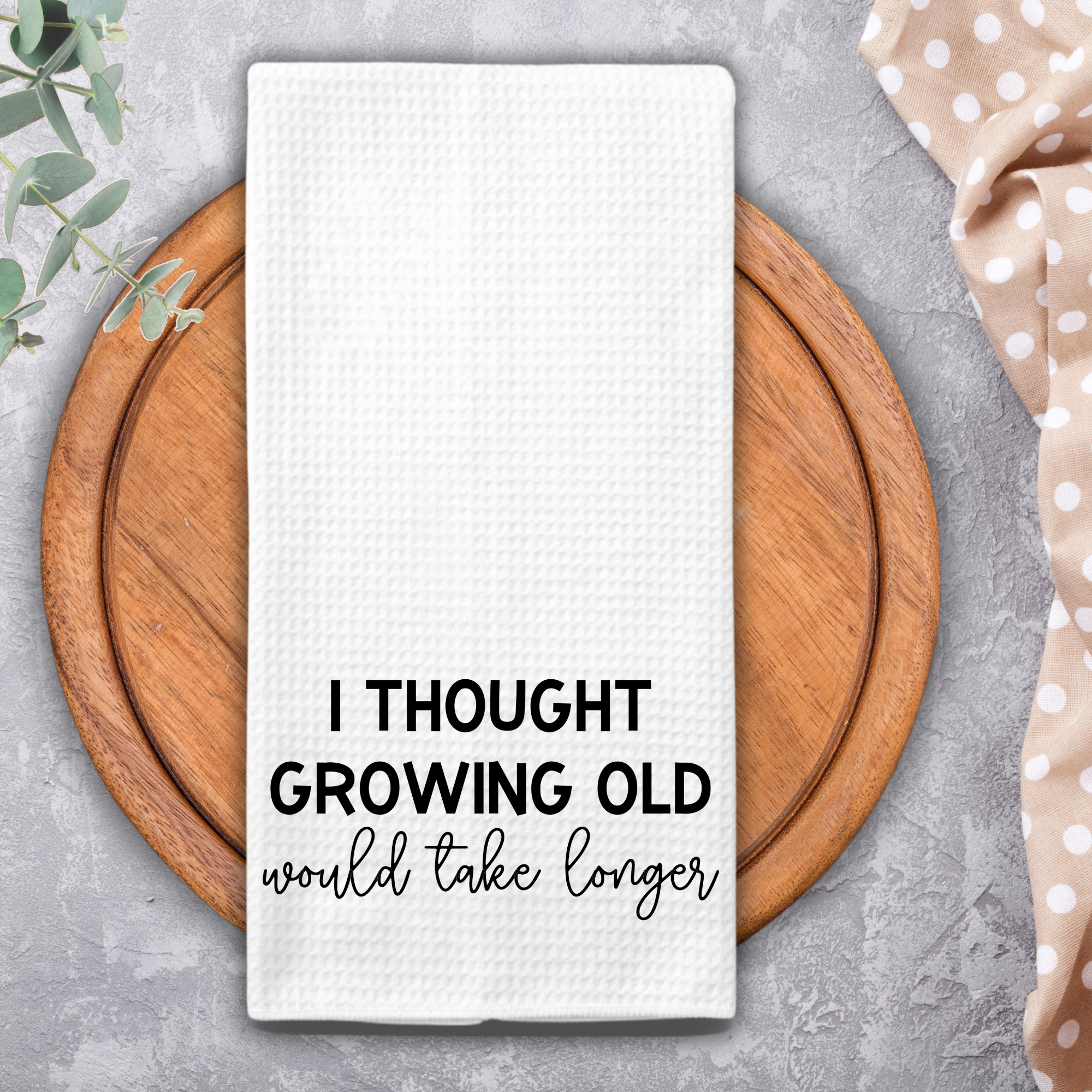 Absorbent microfiber kitchen towel with humorous saying styled on round wooden tray.